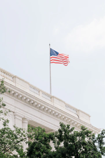 American flag waves atop a white building.