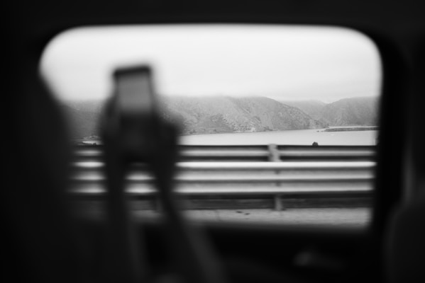 View through car window of person holding phone