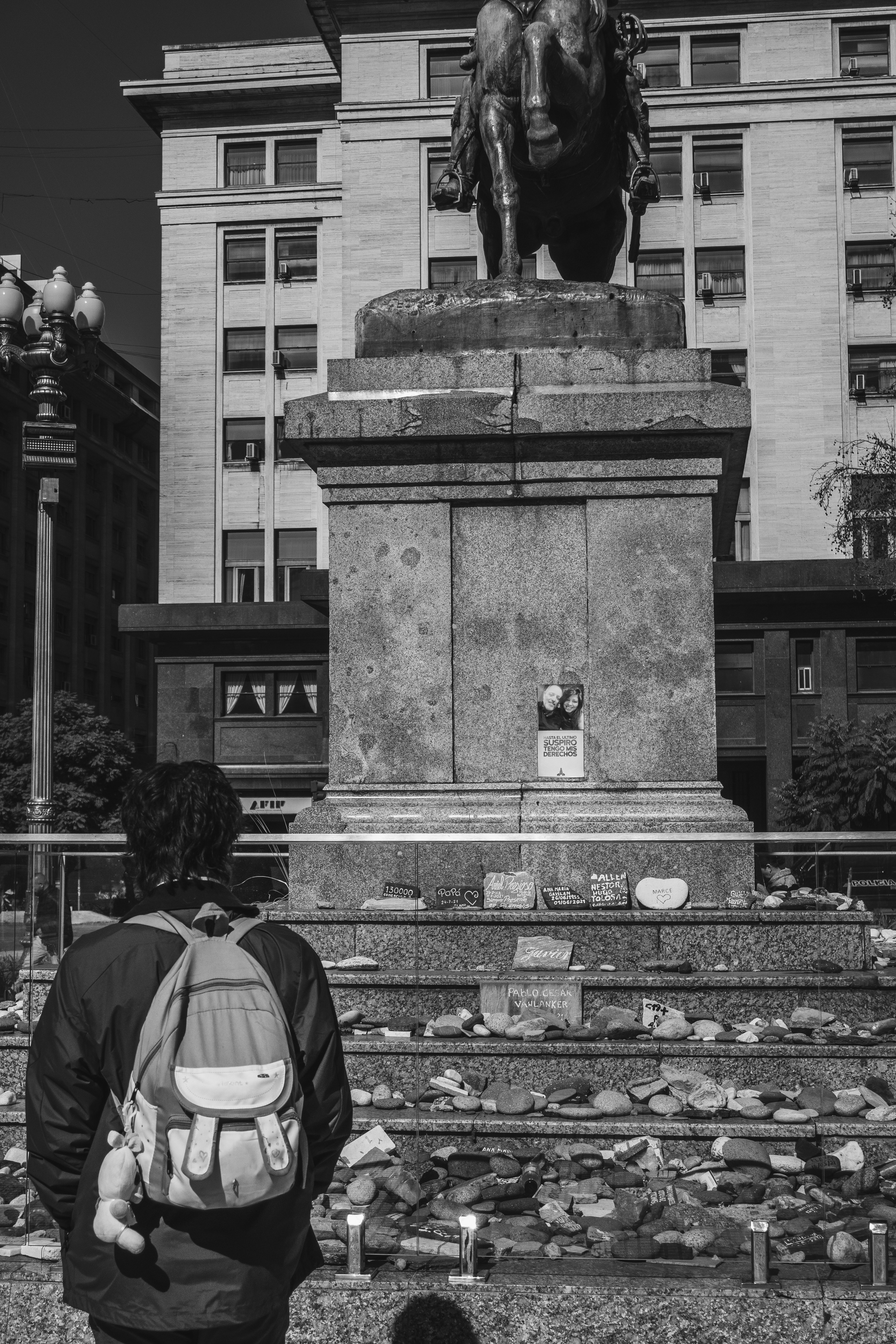 Person looks at a monument with many offerings