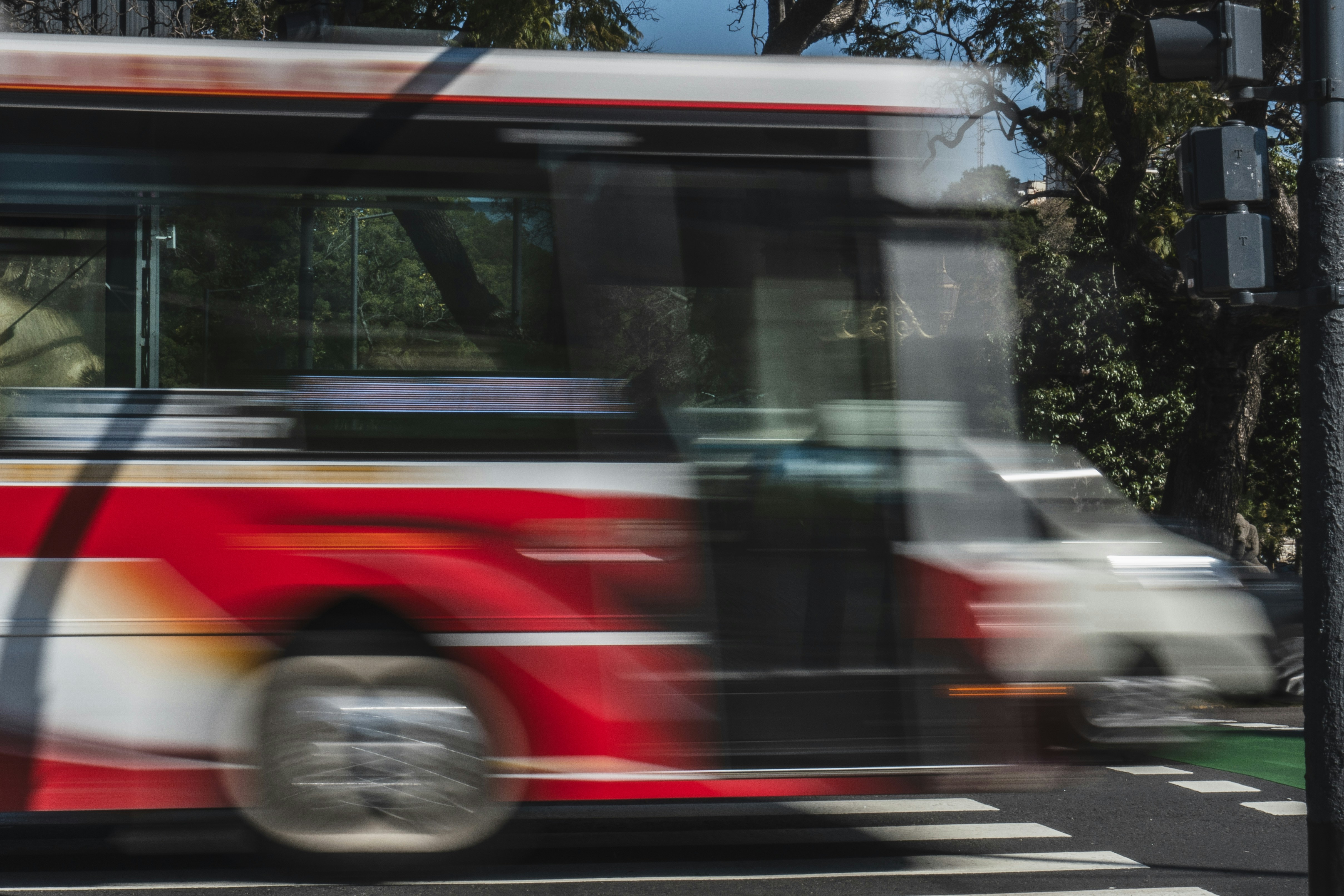 Red and white bus blurred in motion on street