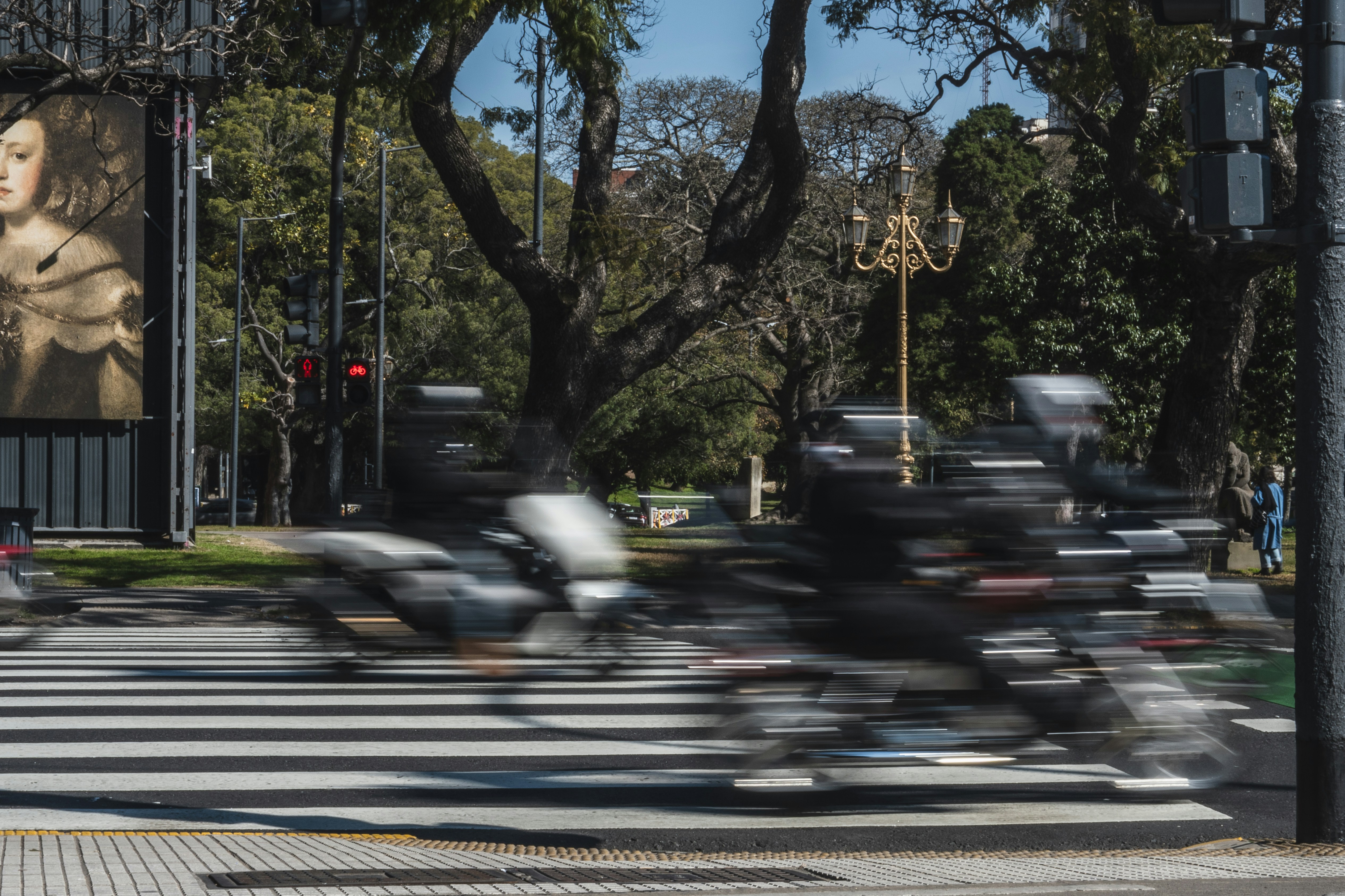 Motorcyclists blurred crossing a street in a city