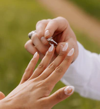 Man places engagement ring on woman's finger