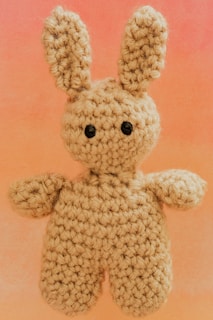 A crocheted bunny with black button eyes