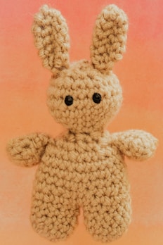 A crocheted bunny with black button eyes