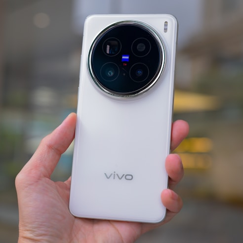 Hand holding a white vivo smartphone with large camera module