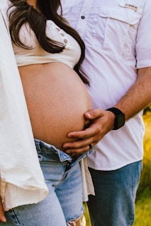Couple holding pregnant belly outdoors