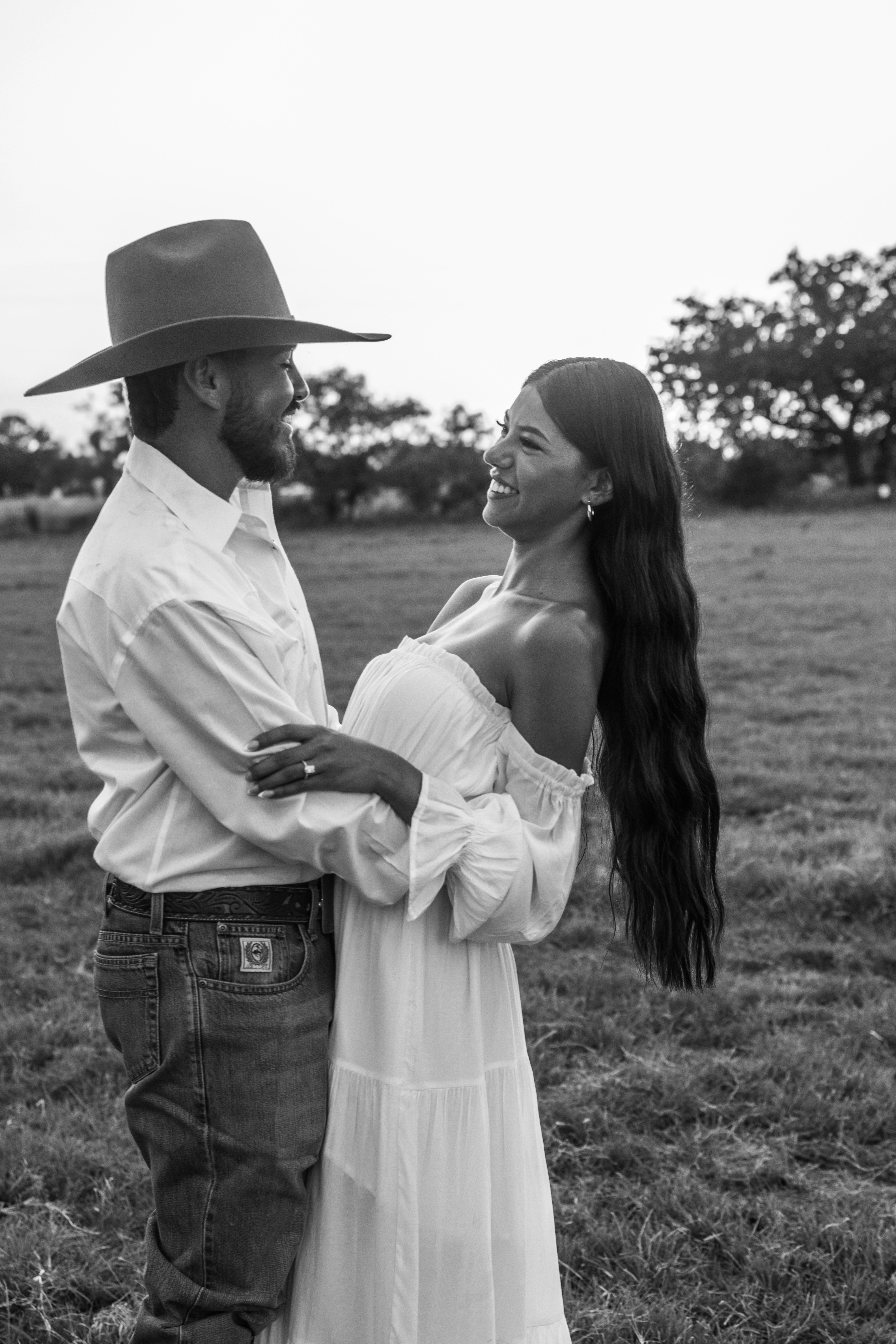 Couple embracing in a field at sunset