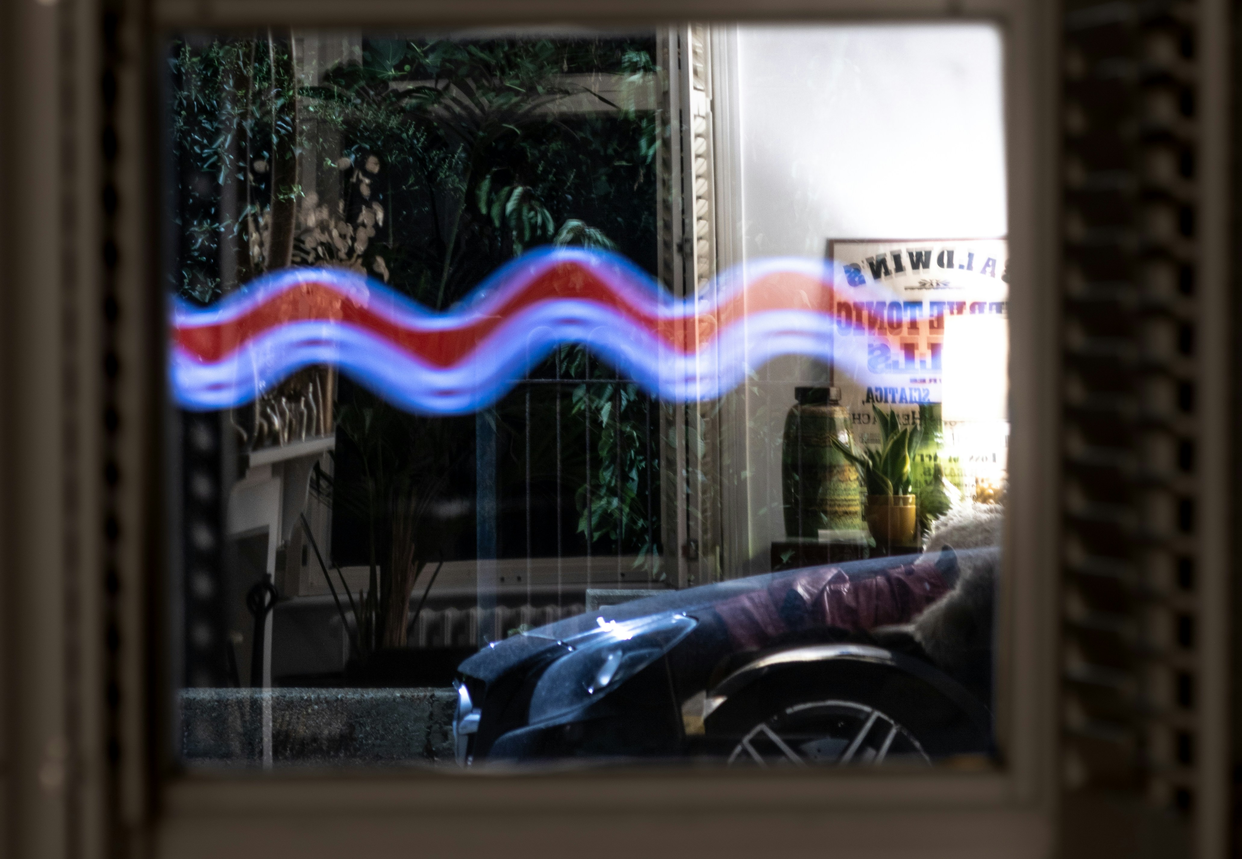 Wellenförmige blaue und rote Lichtstreifen über das Fenster