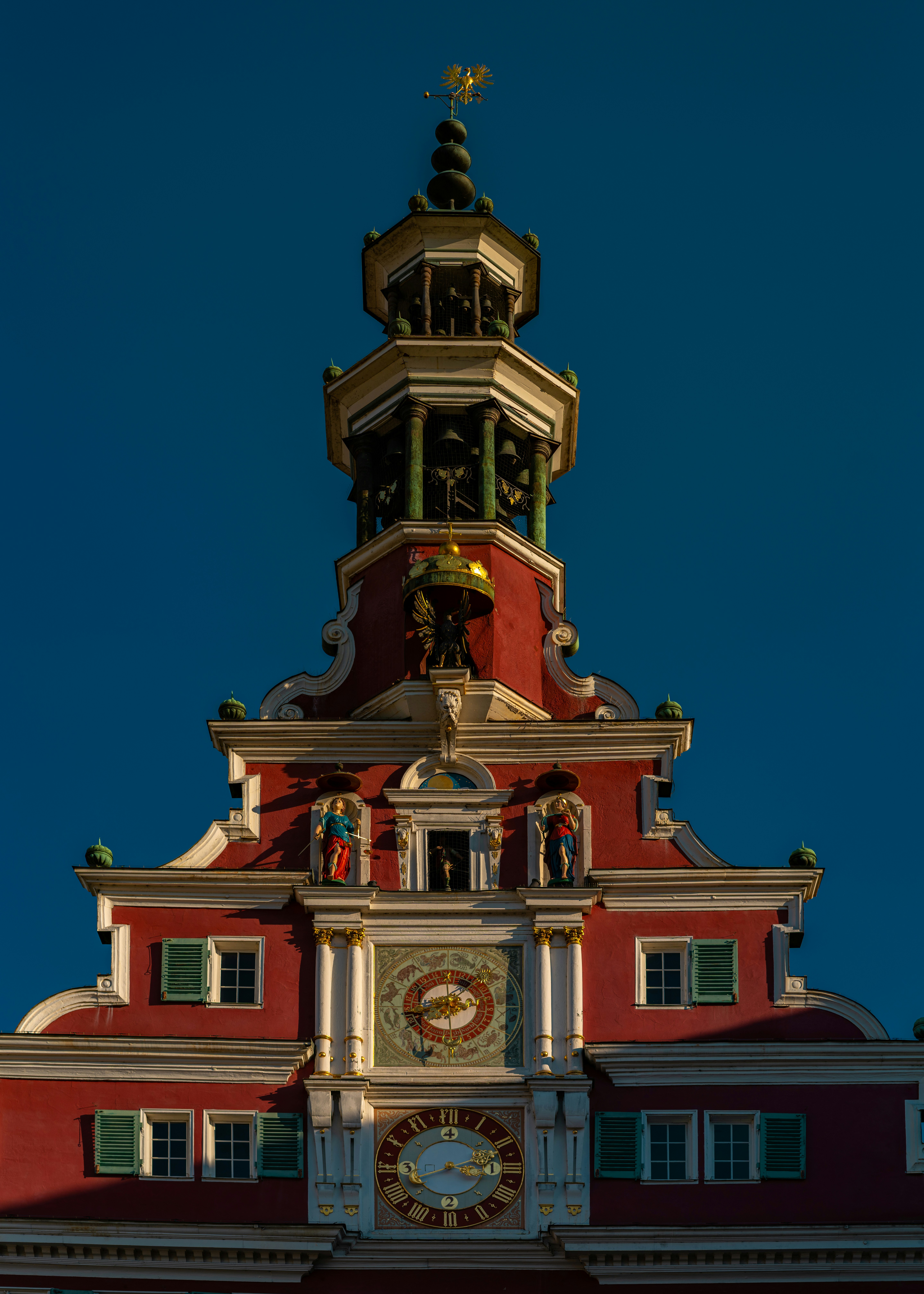 Ornate red building facade with a clock tower.