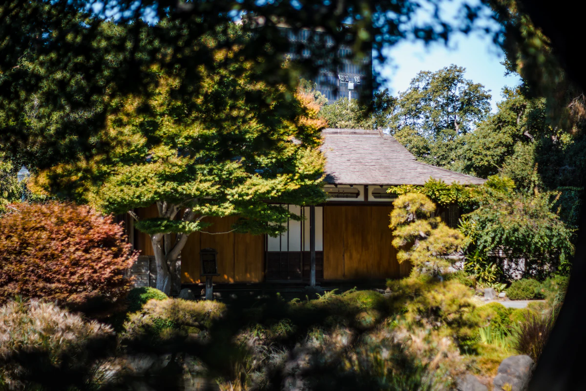 Traditional Japanese house surrounded by lush green garden — representative of ryokan properties available on Booking.com