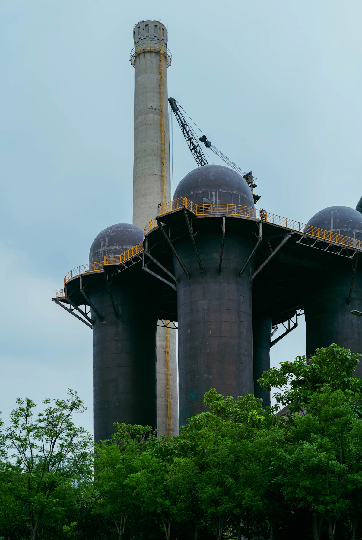 Industrial factory with tall smokestacks representing biomass gasification facilities