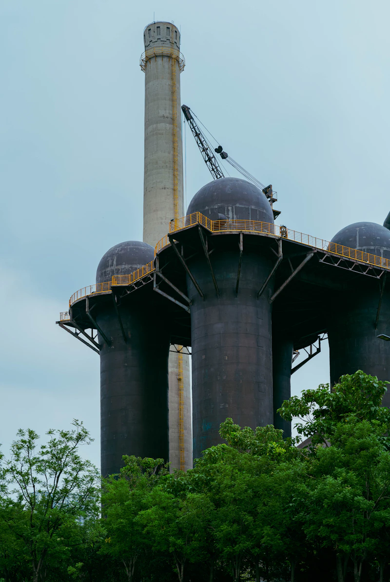 Industrial factory with tall smokestacks representing biomass gasification facilities
