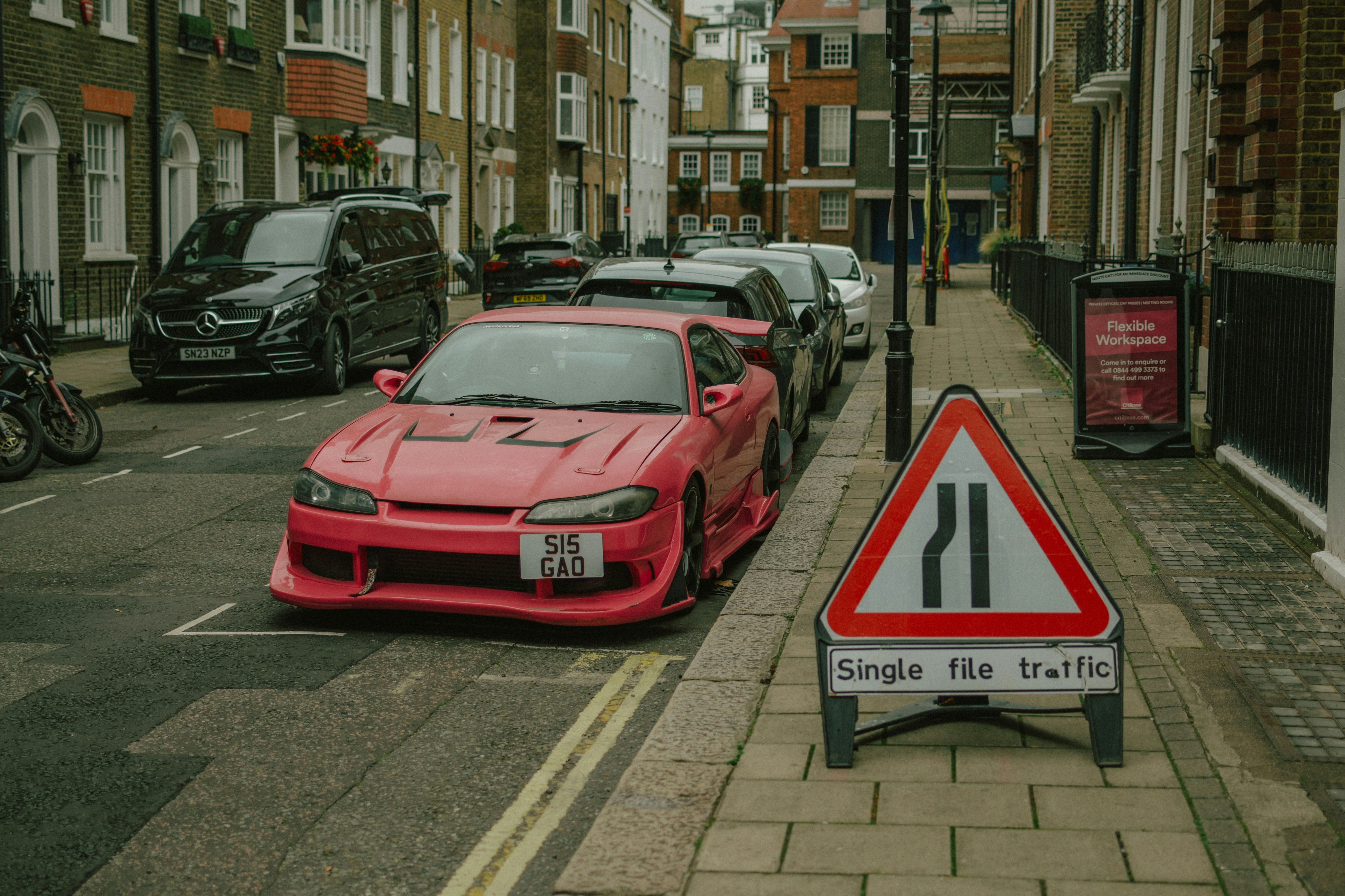 Pinker Sportwagen, der auf einer Straße in der Stadt geparkt ist