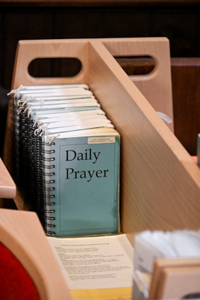 Daily prayer books in a wooden holder.