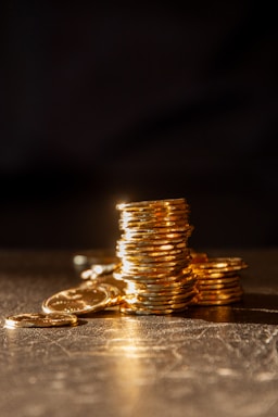 Stacks of gold coins on a dark, textured surface