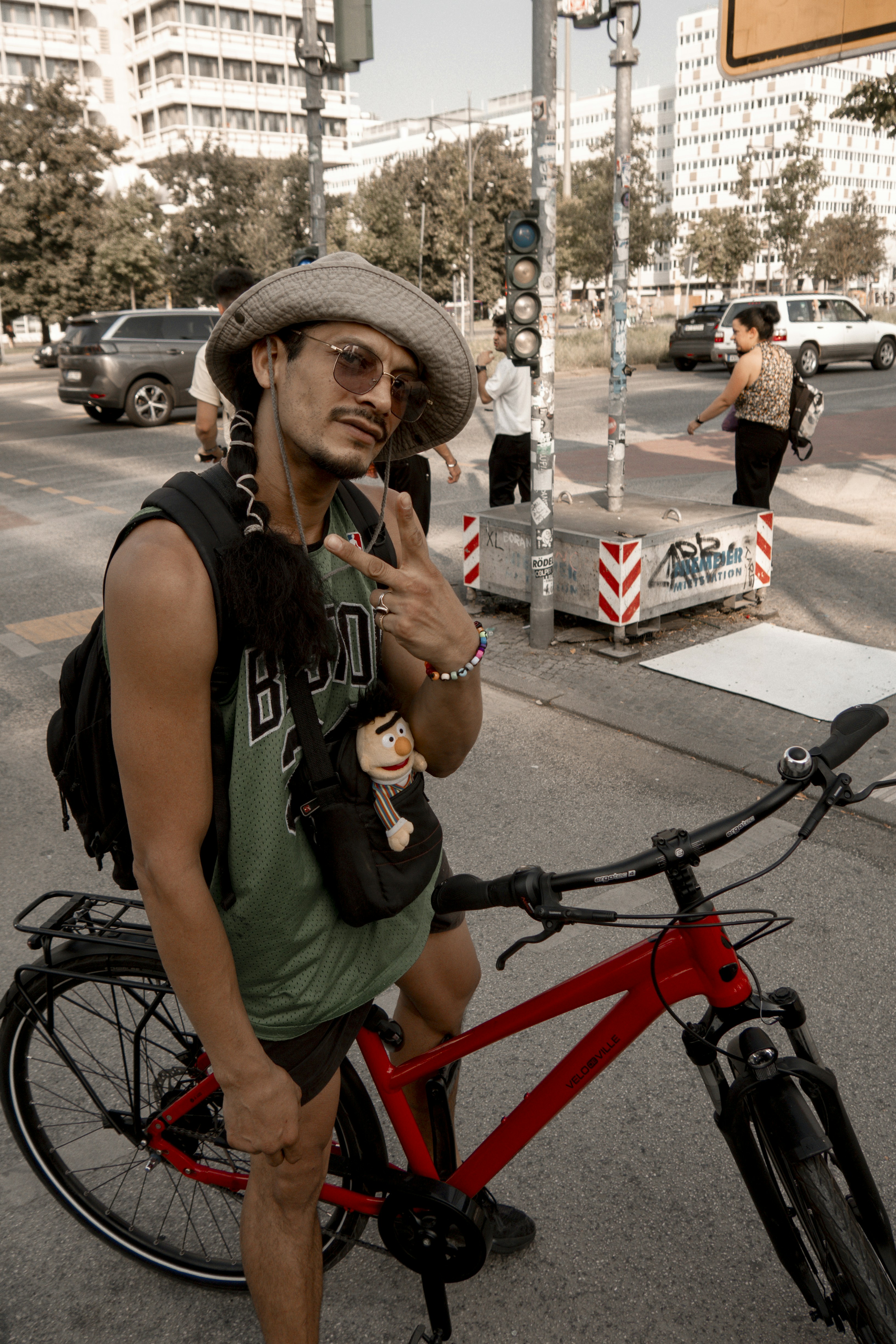 Man with hat and sunglasses poses by bicycle
