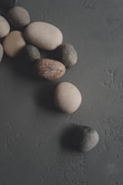 Smooth, varied stones arranged on a textured surface.
