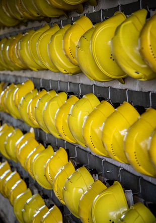 Rows of yellow hard hats hanging on a rack