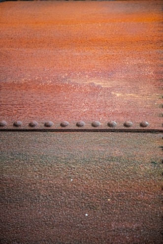 Rusted metal surface with a line of rivets