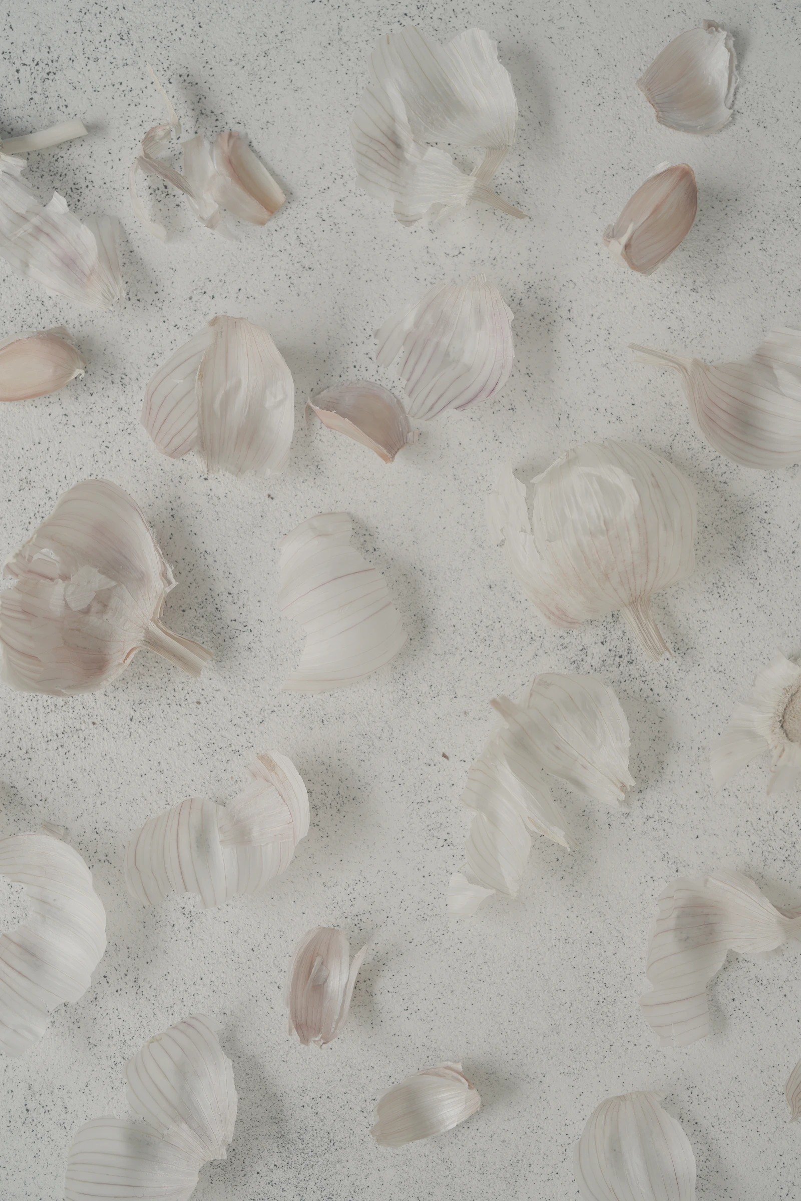 Garlic cloves and papery peels on a kitchen surface