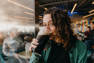 Woman drinking a dark beer in a brewery