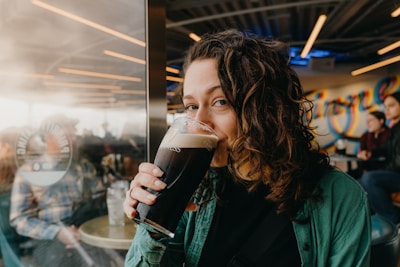 Woman drinking a dark beer in a brewery