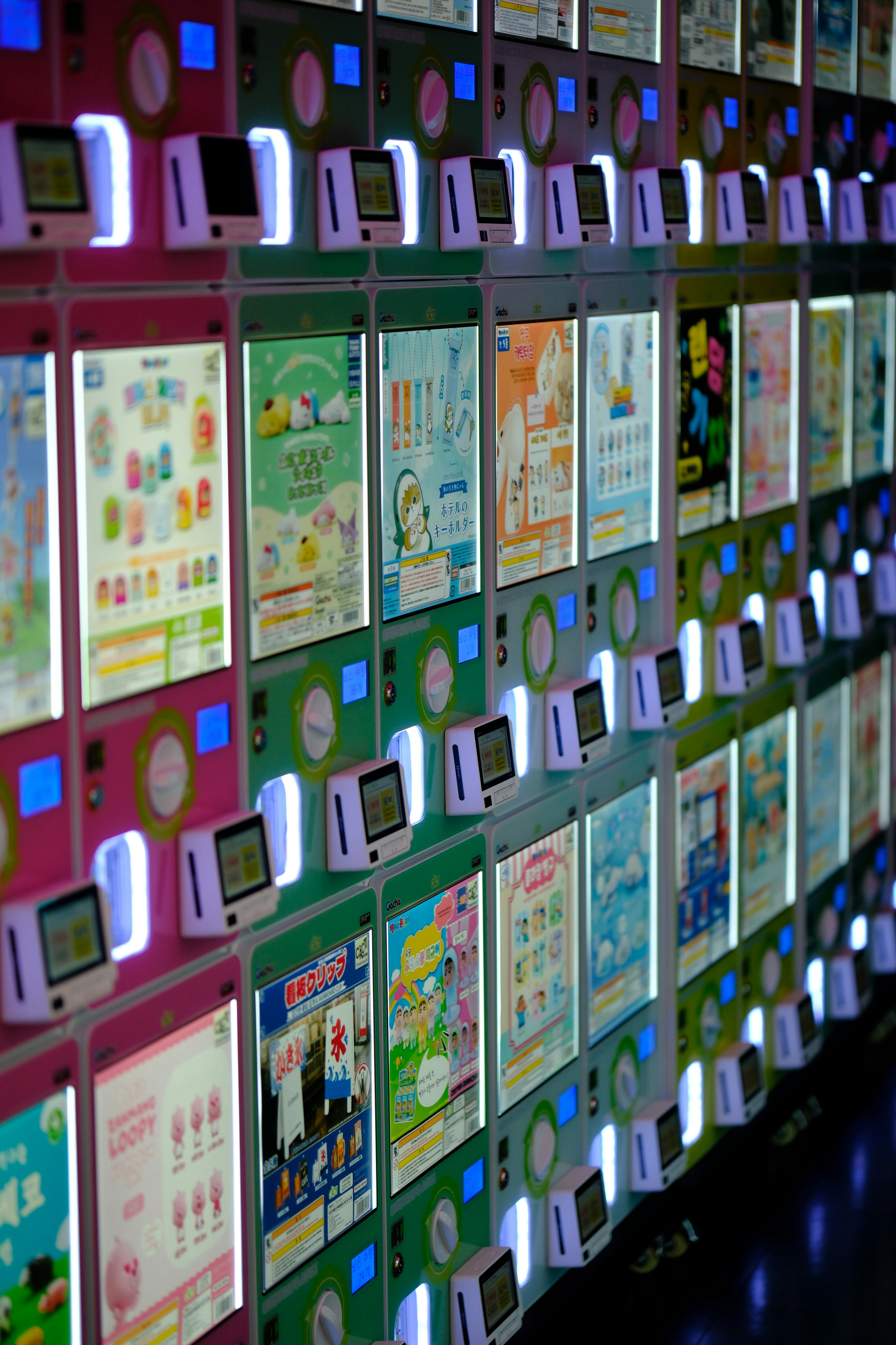 Wall of colorful vending machines with illuminated displays.