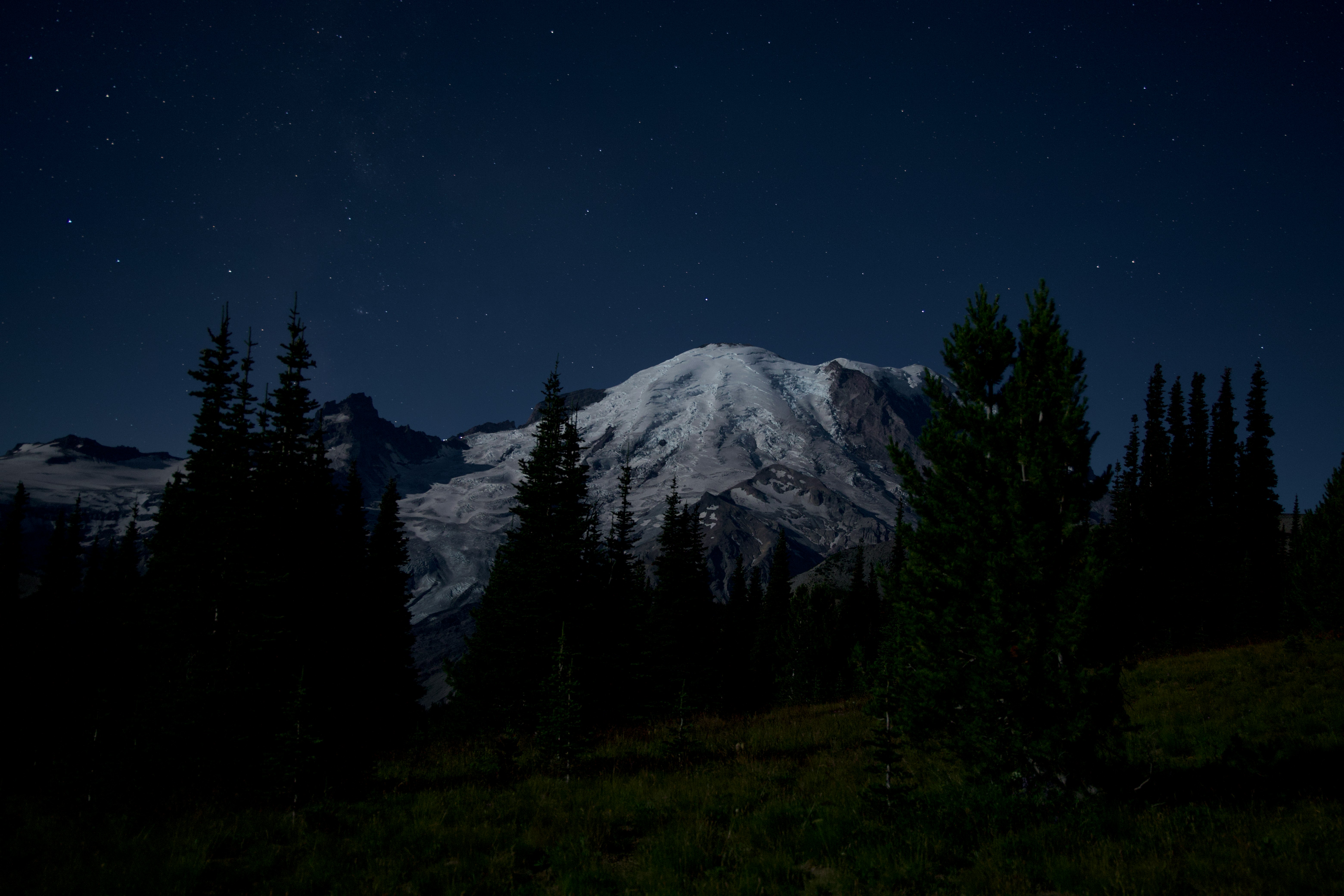Snowy mountain peak under a starry night sky