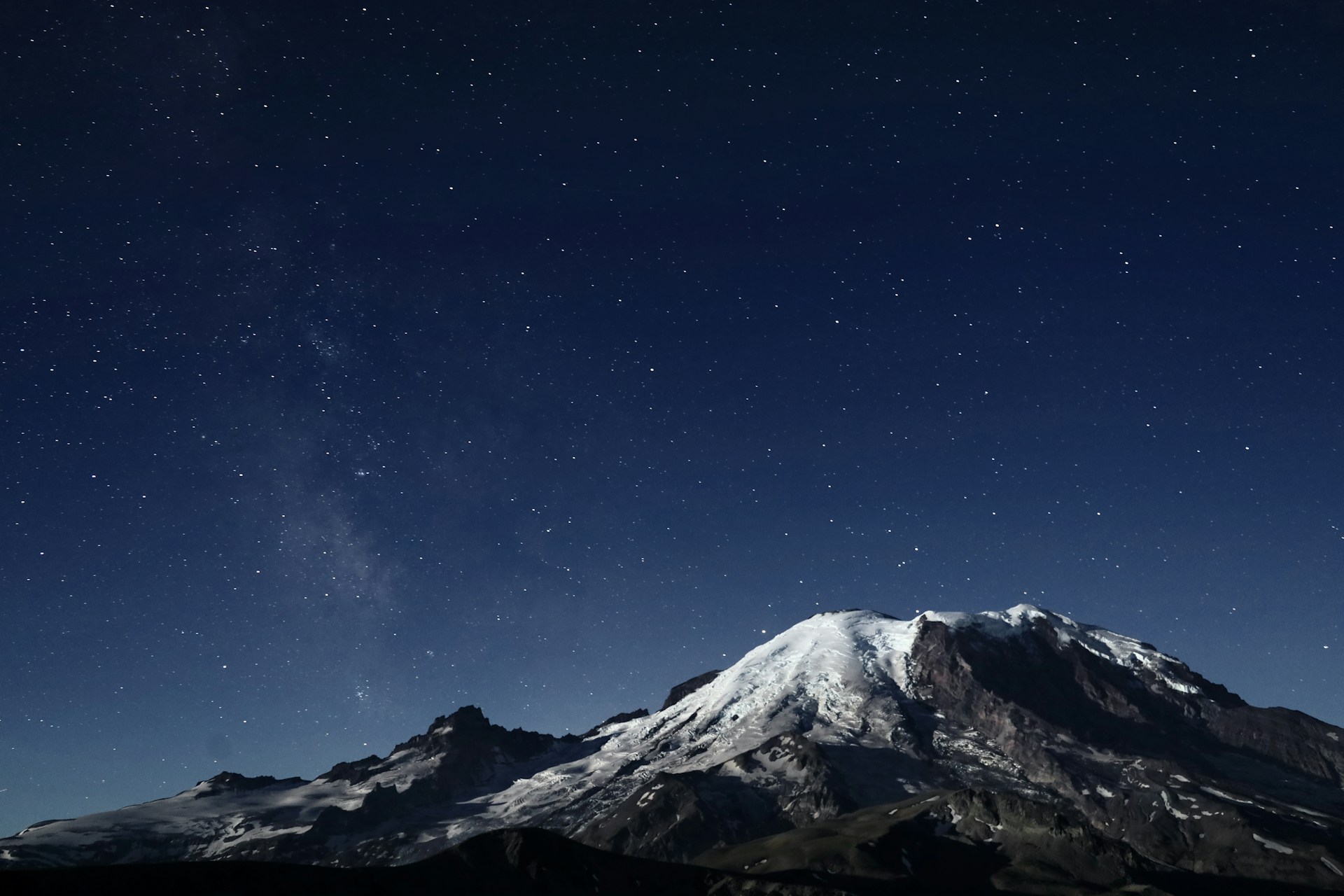 Snow-capped mountain under a starry night sky