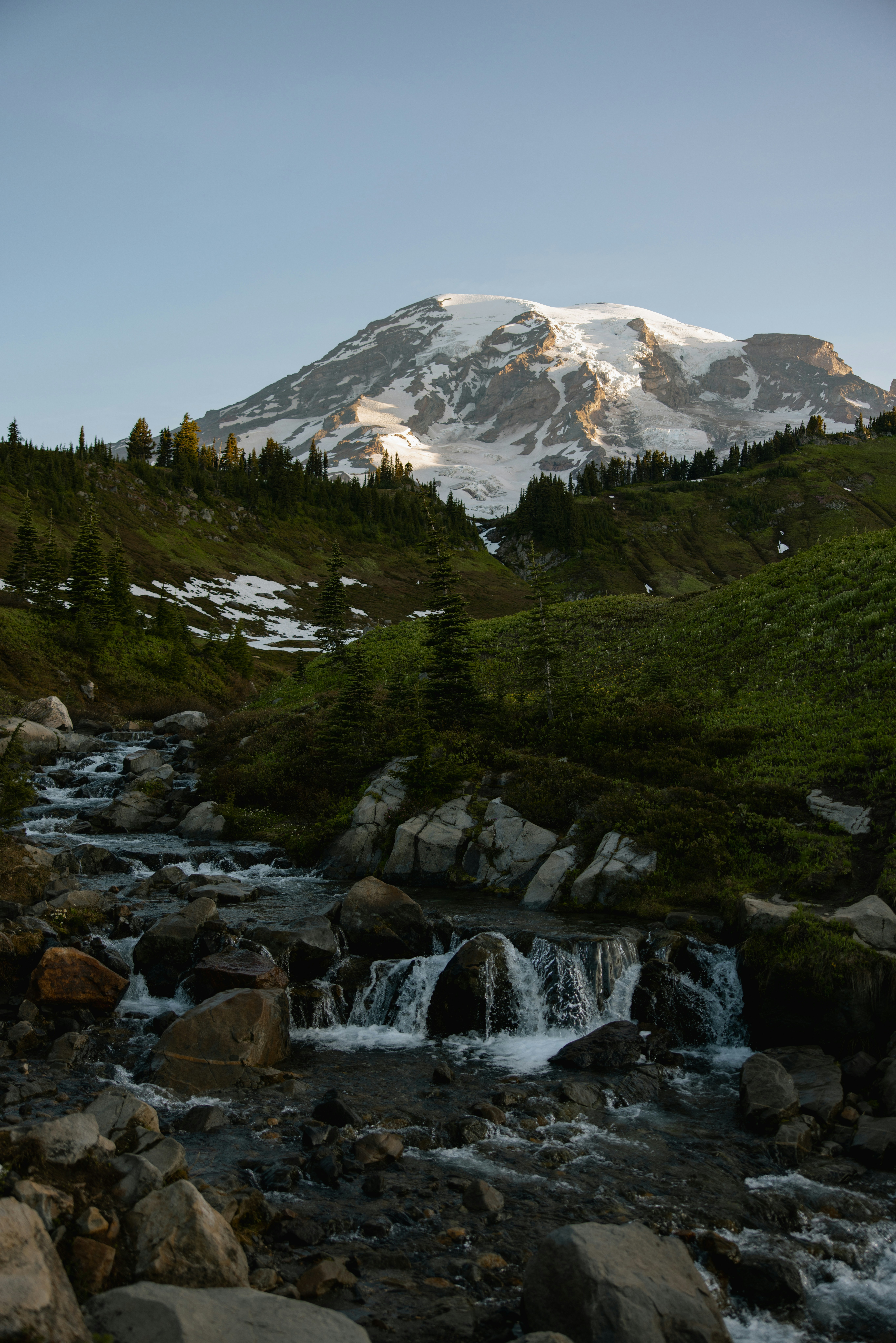Snow-capped mountain peak with a stream in foreground