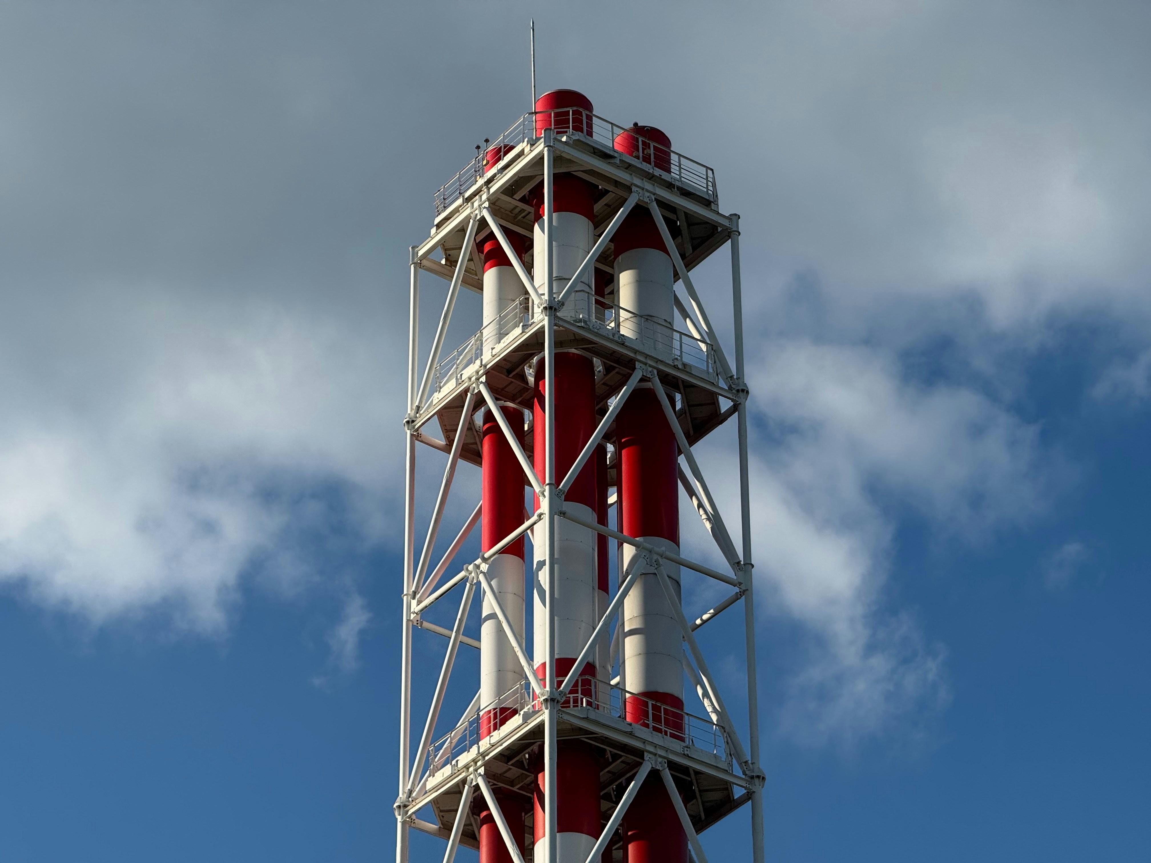 Industrial chimney with red and white pipes