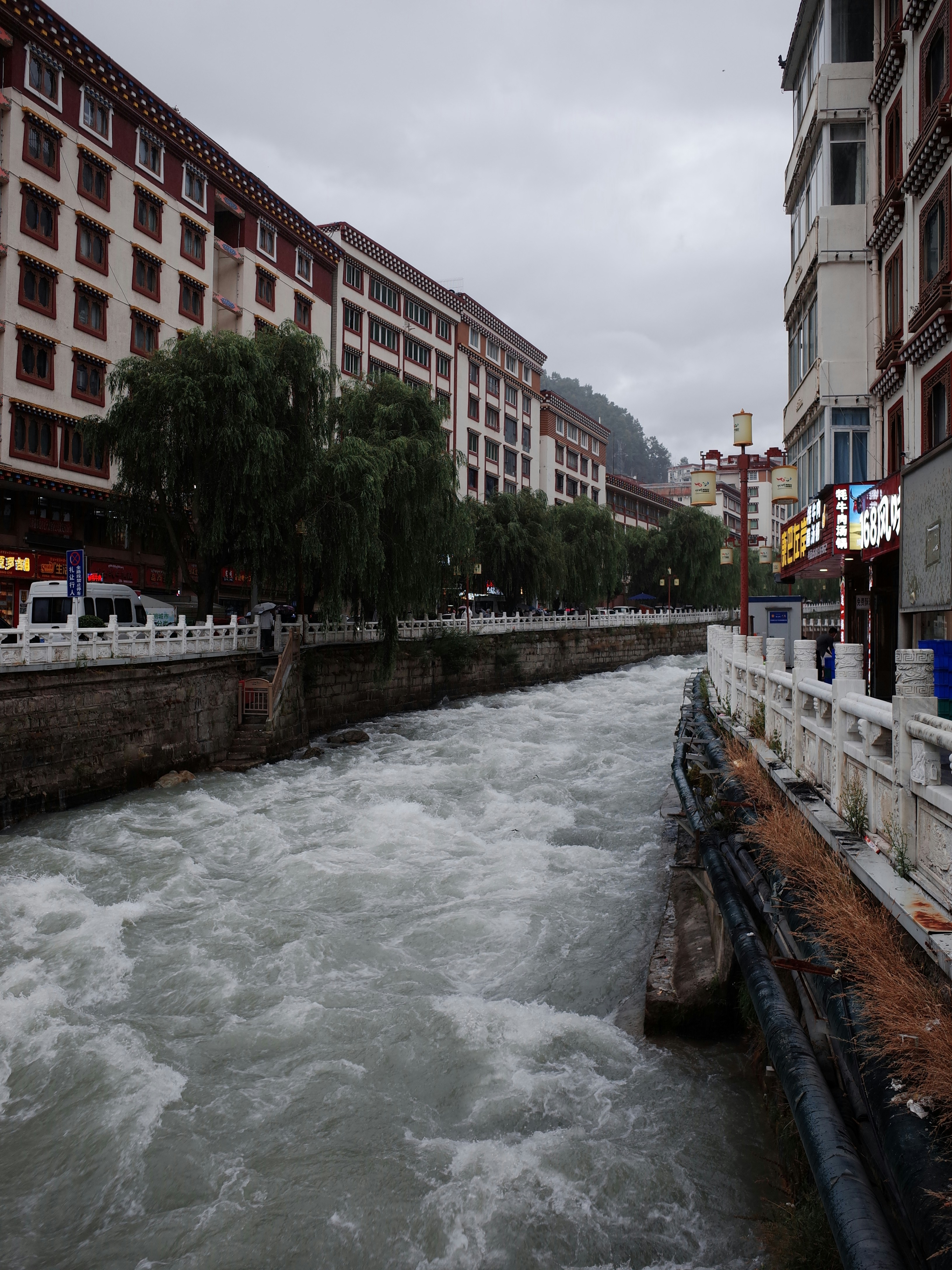 Fast flowing river through a city with buildings. photo – Free Car ...