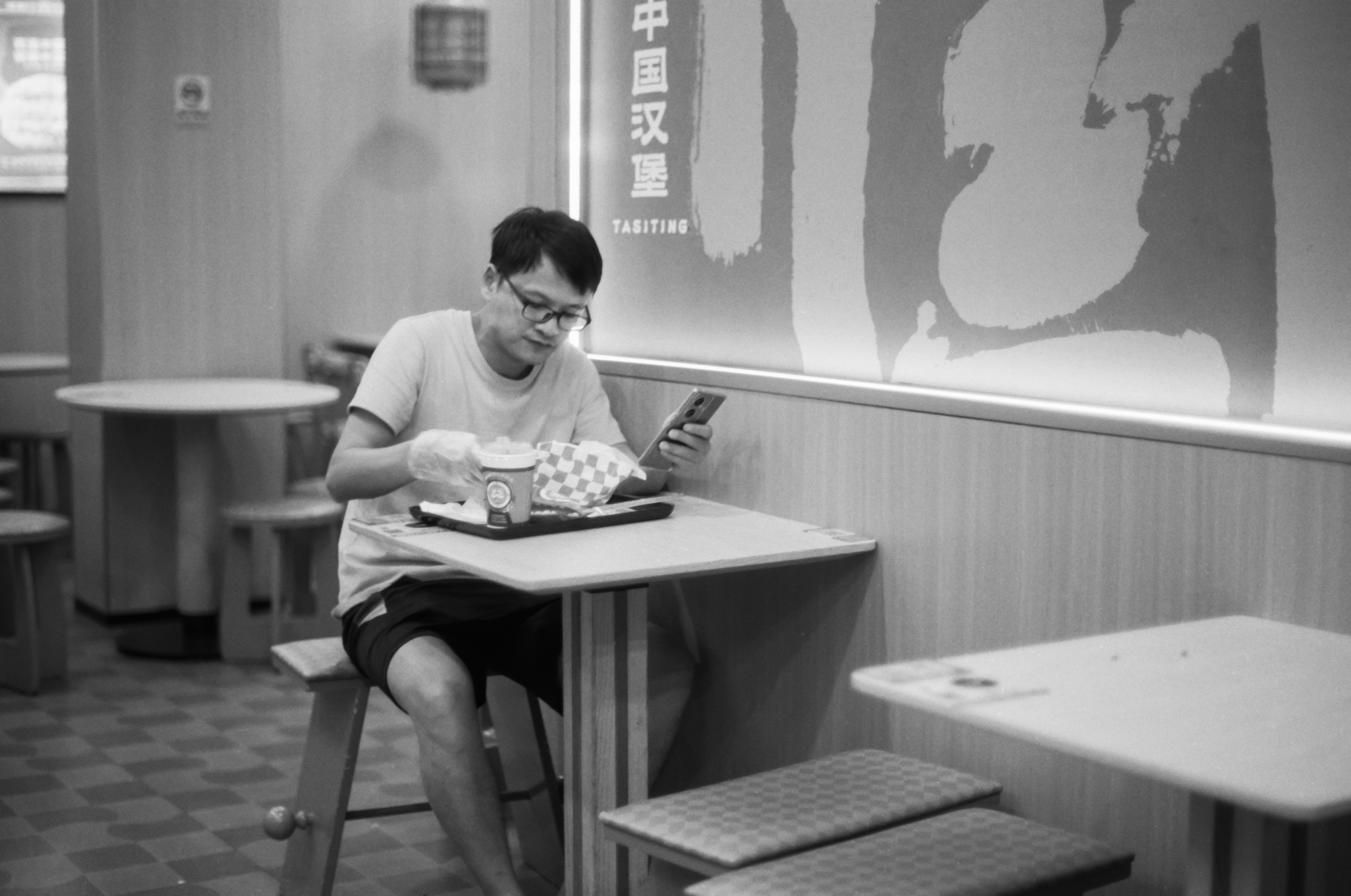 Man sitting at table with food and phone