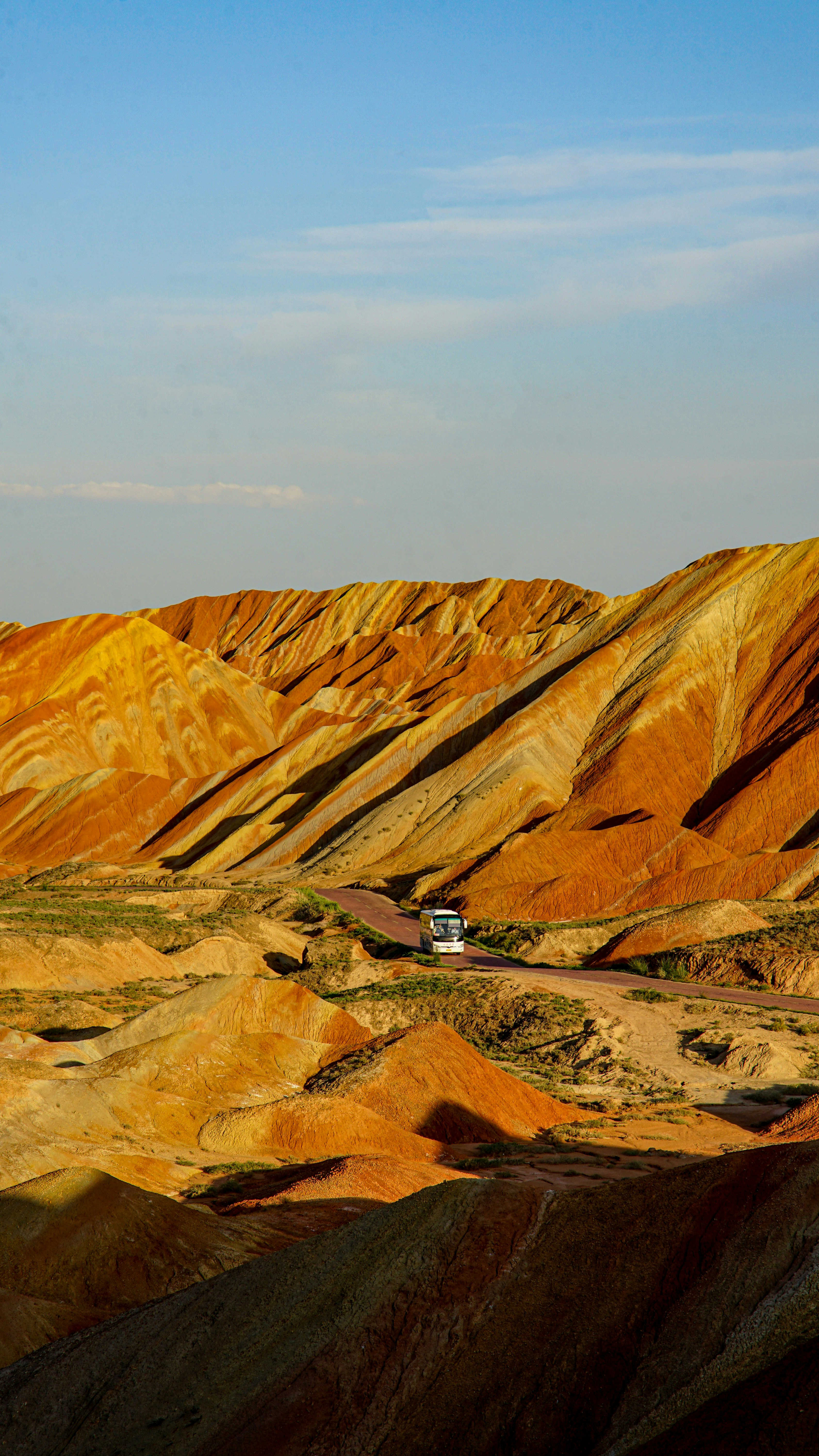 Colorful rainbow mountains with a tour bus on road