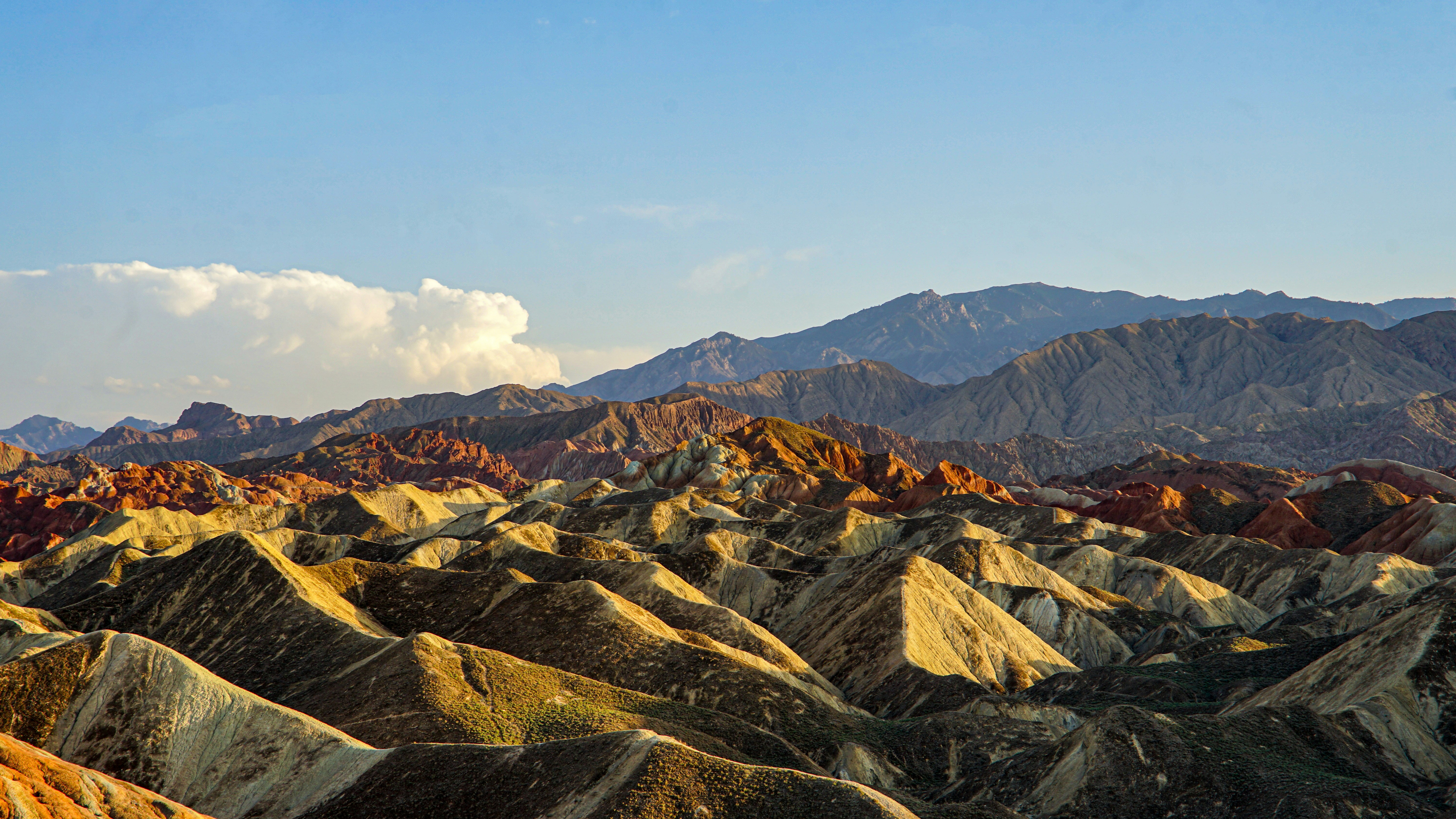 Colorful rolling hills under a bright blue sky