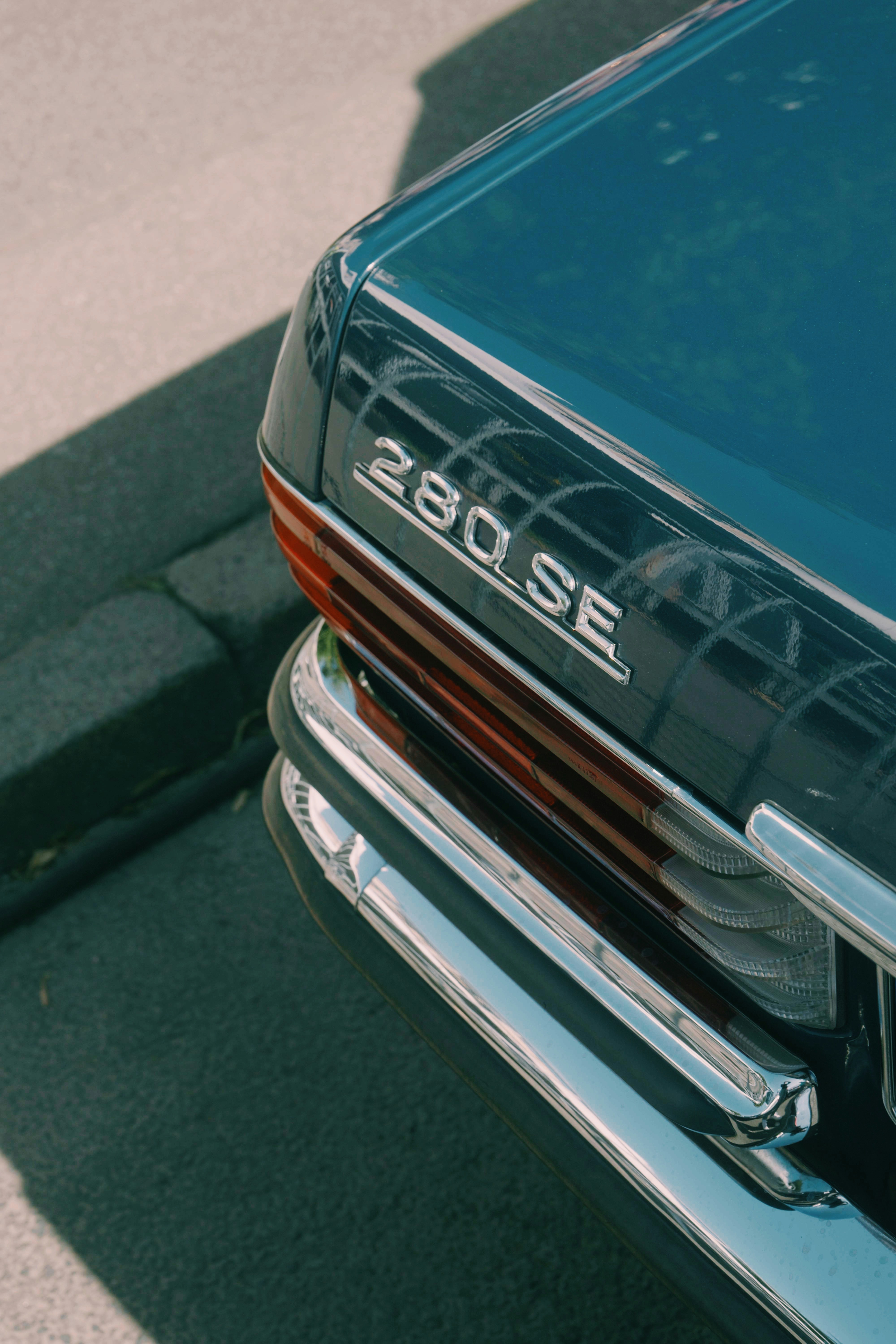 Close-up of a vintage blue car's rear emblem.
