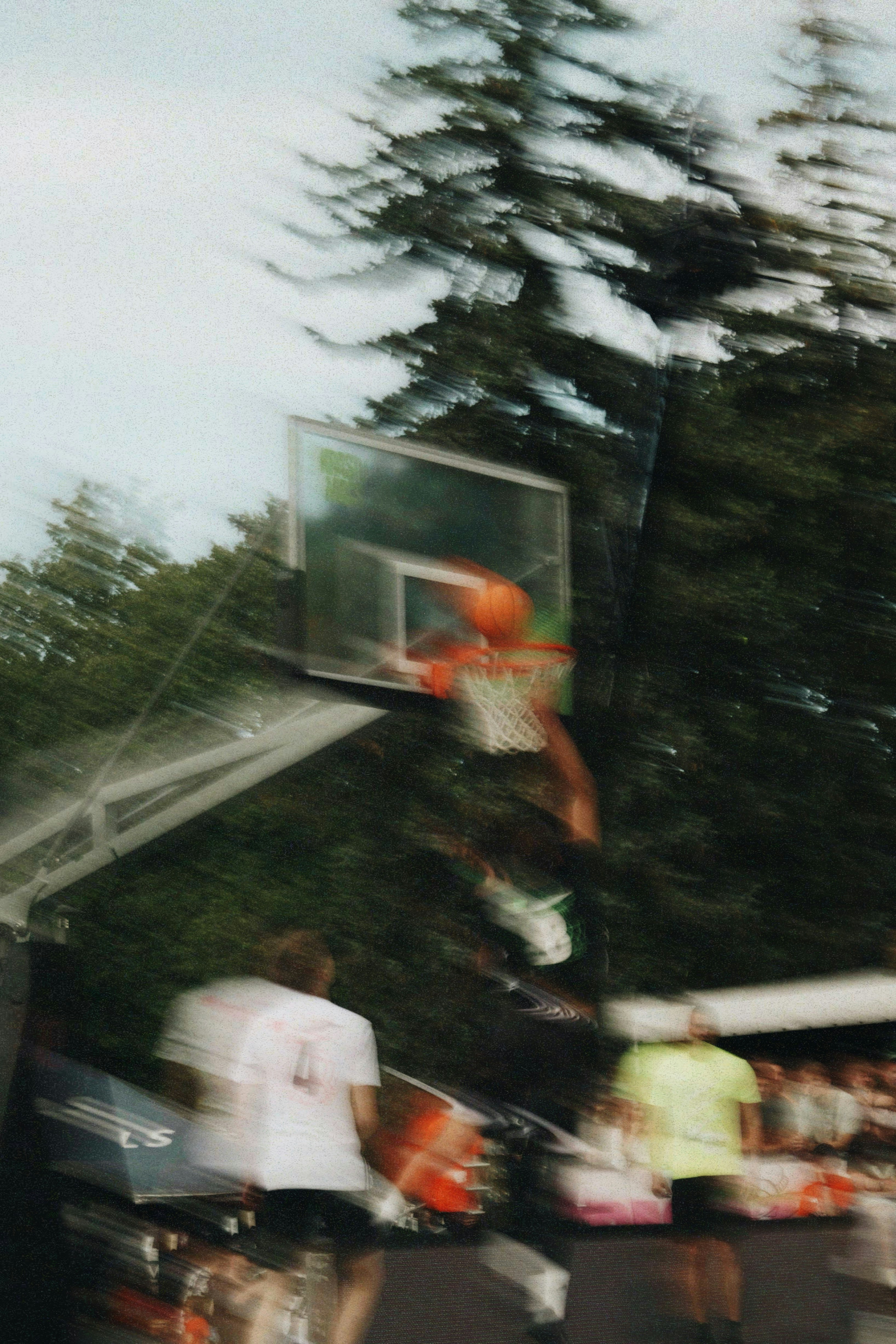Basketball player jumping to dunk on outdoor court