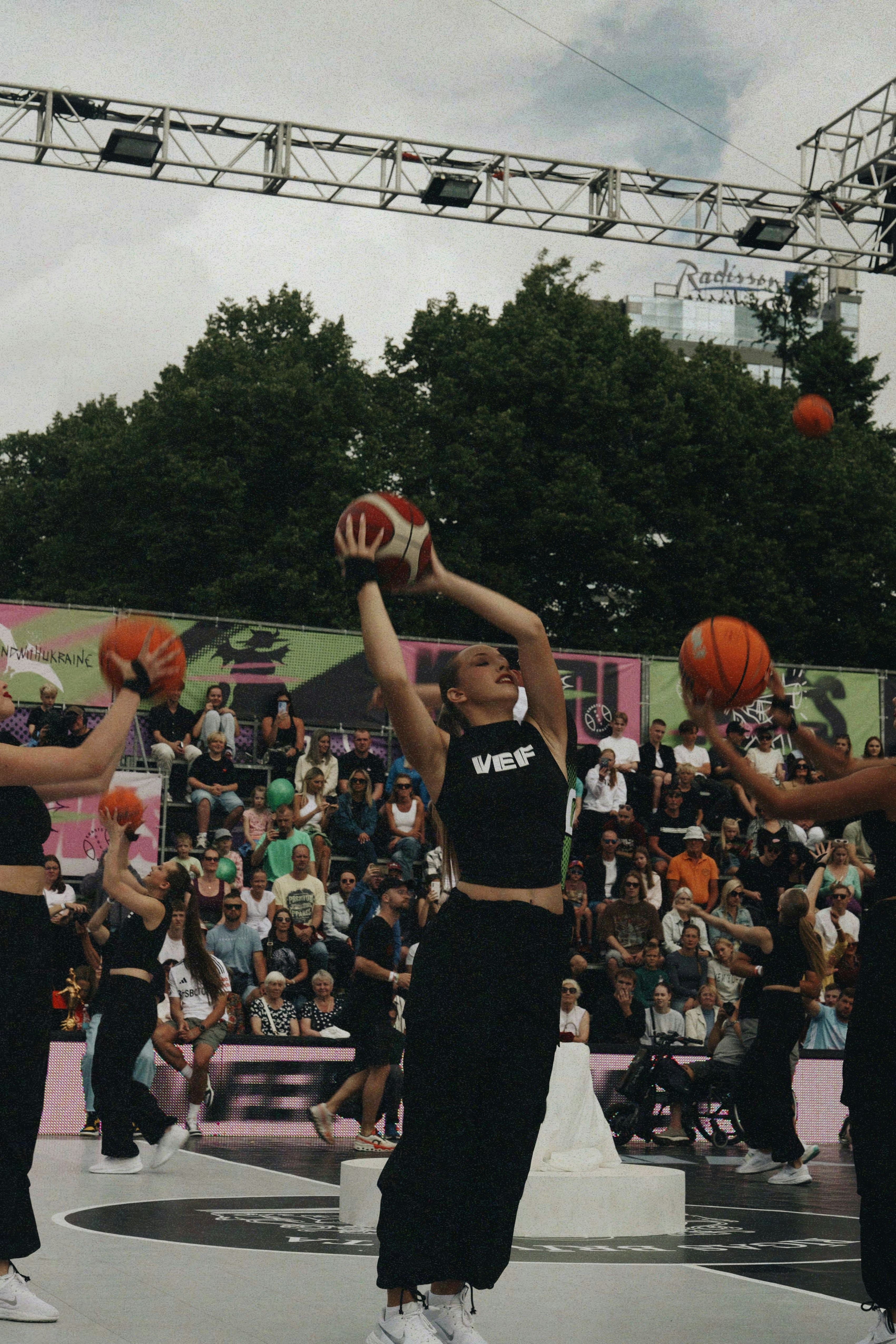 Remaja putri bermain bola basket dengan penonton menonton