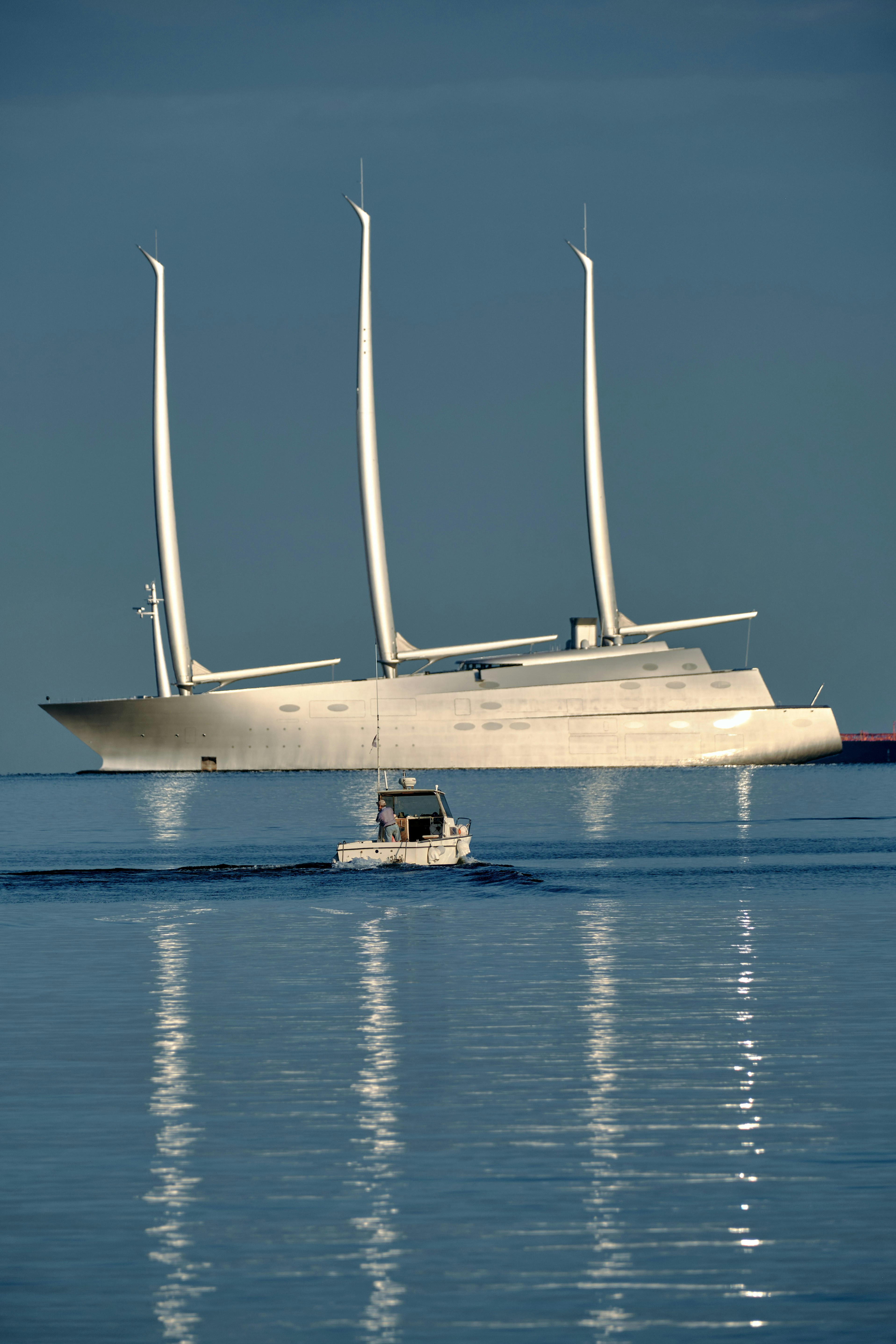 Large white sailing yacht with a small boat.