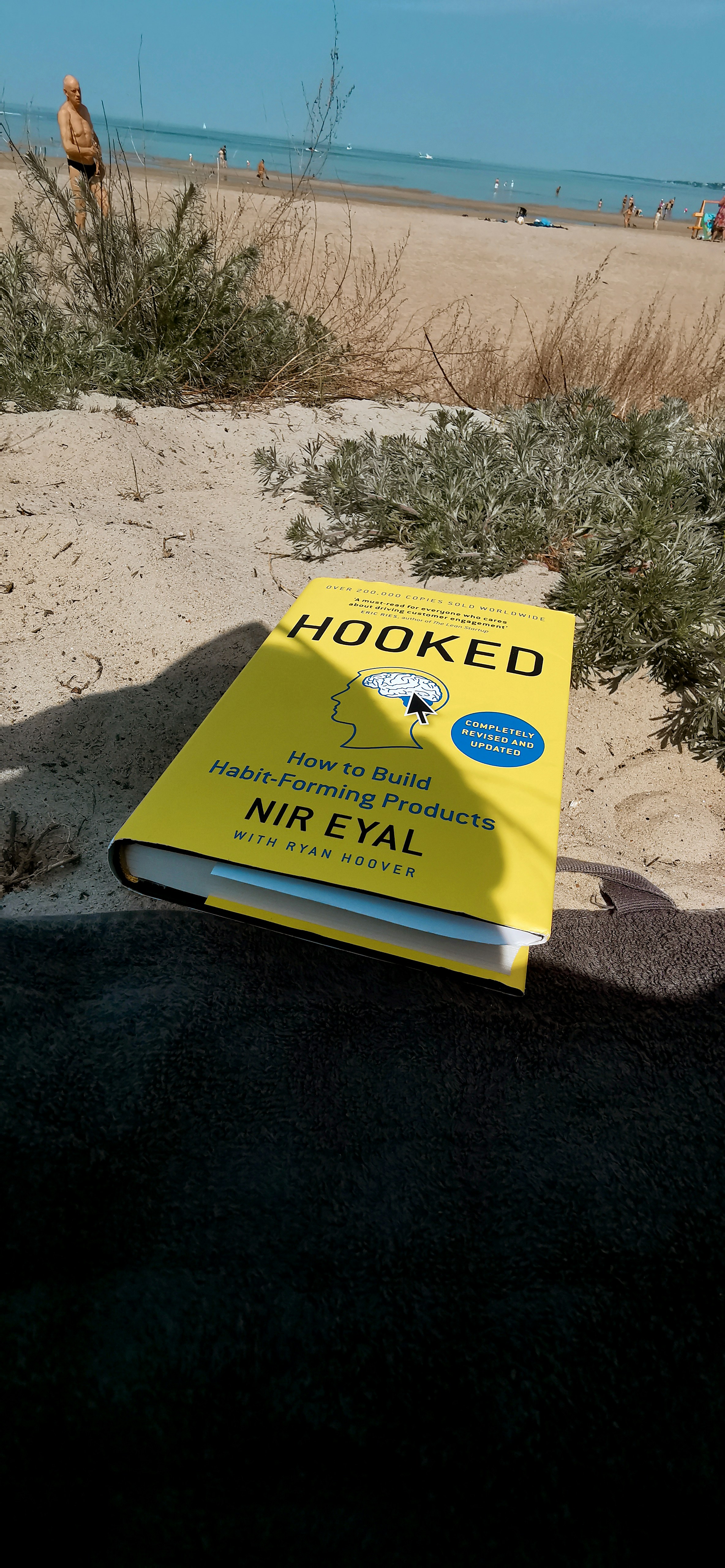 Yellow book on beach sand with ocean background