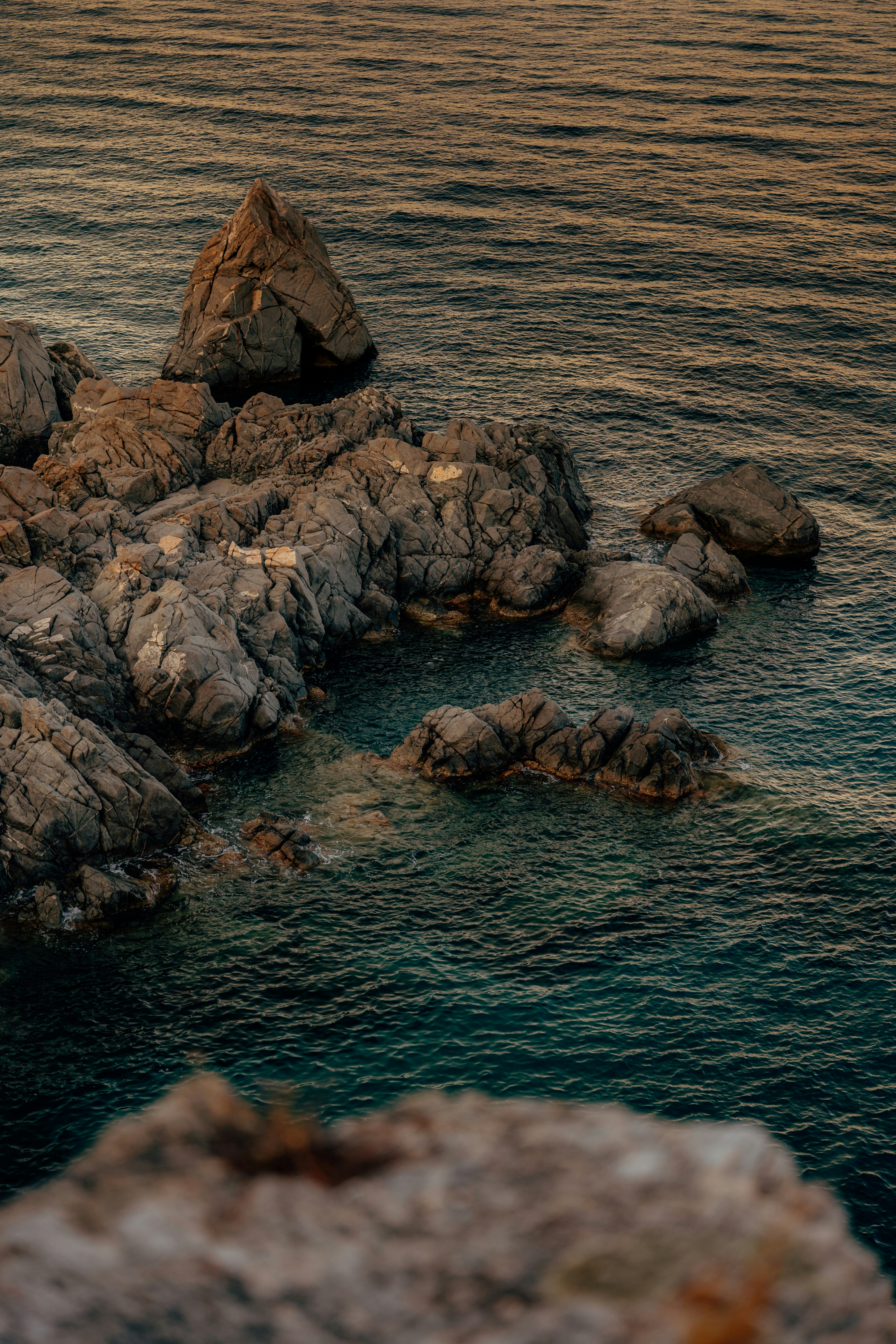 Rocky coastline with calm blue water at sunset