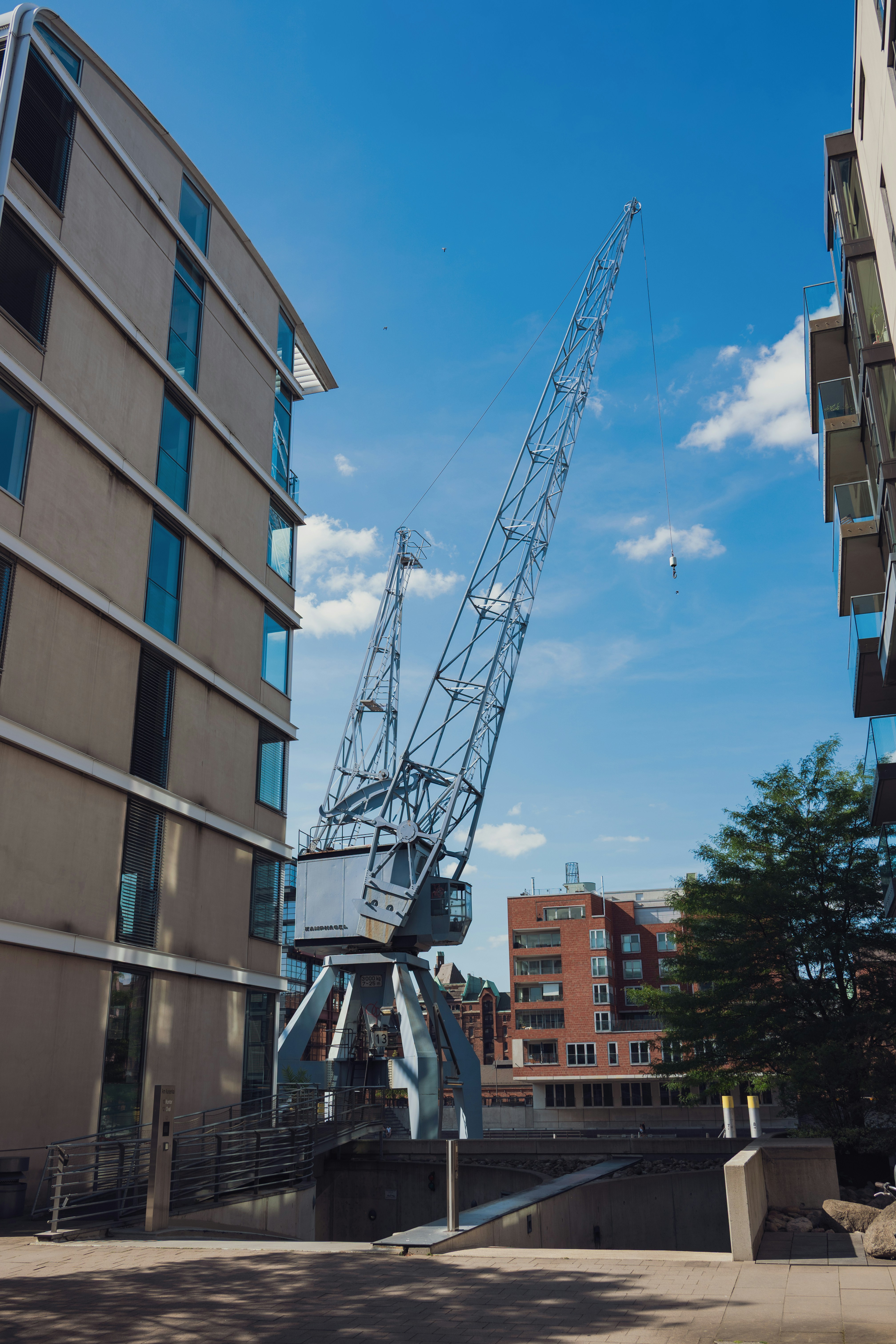 A large industrial crane between modern buildings