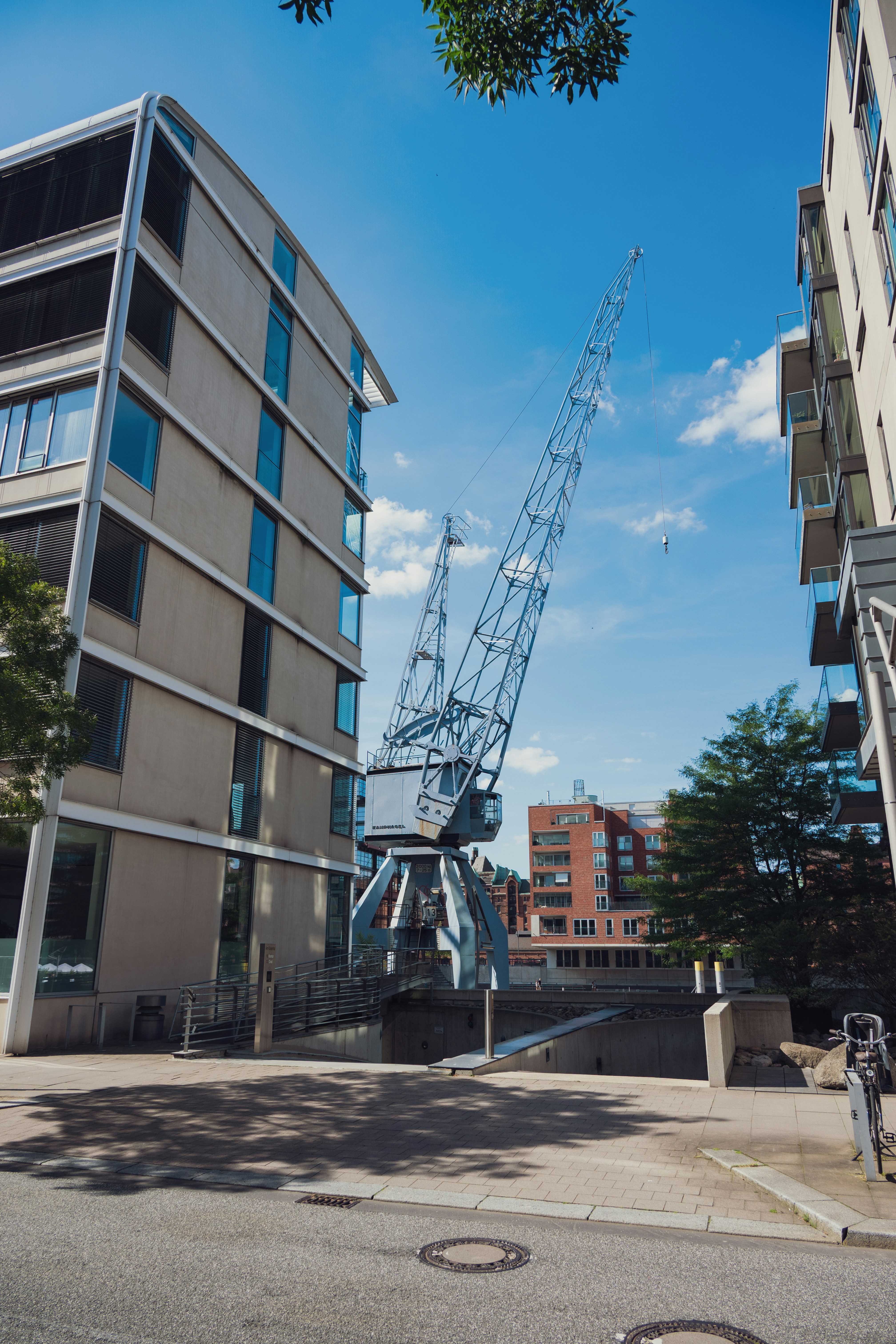 A large industrial crane between modern buildings