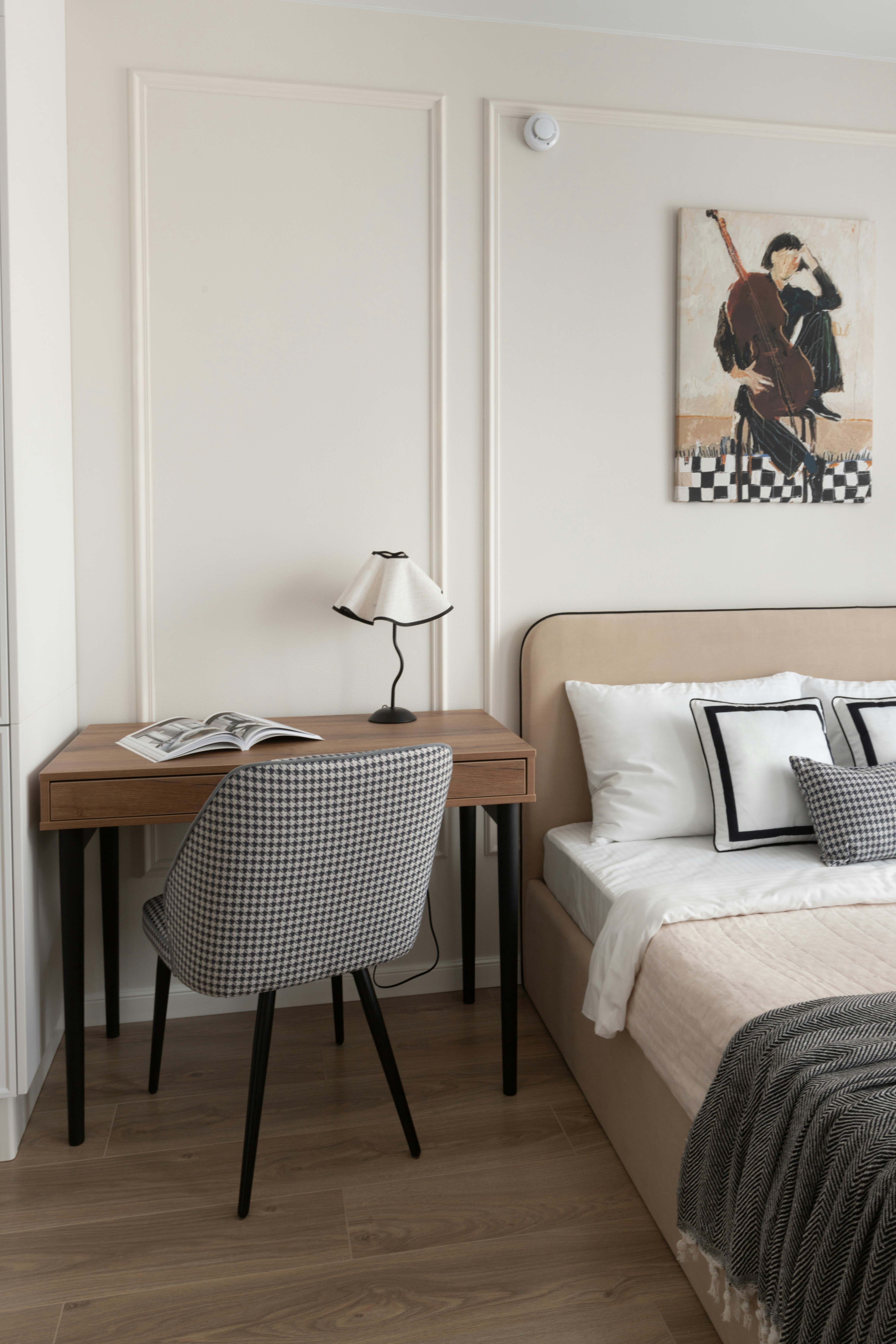 Bedroom with desk, chair, and artwork above bed artwork.