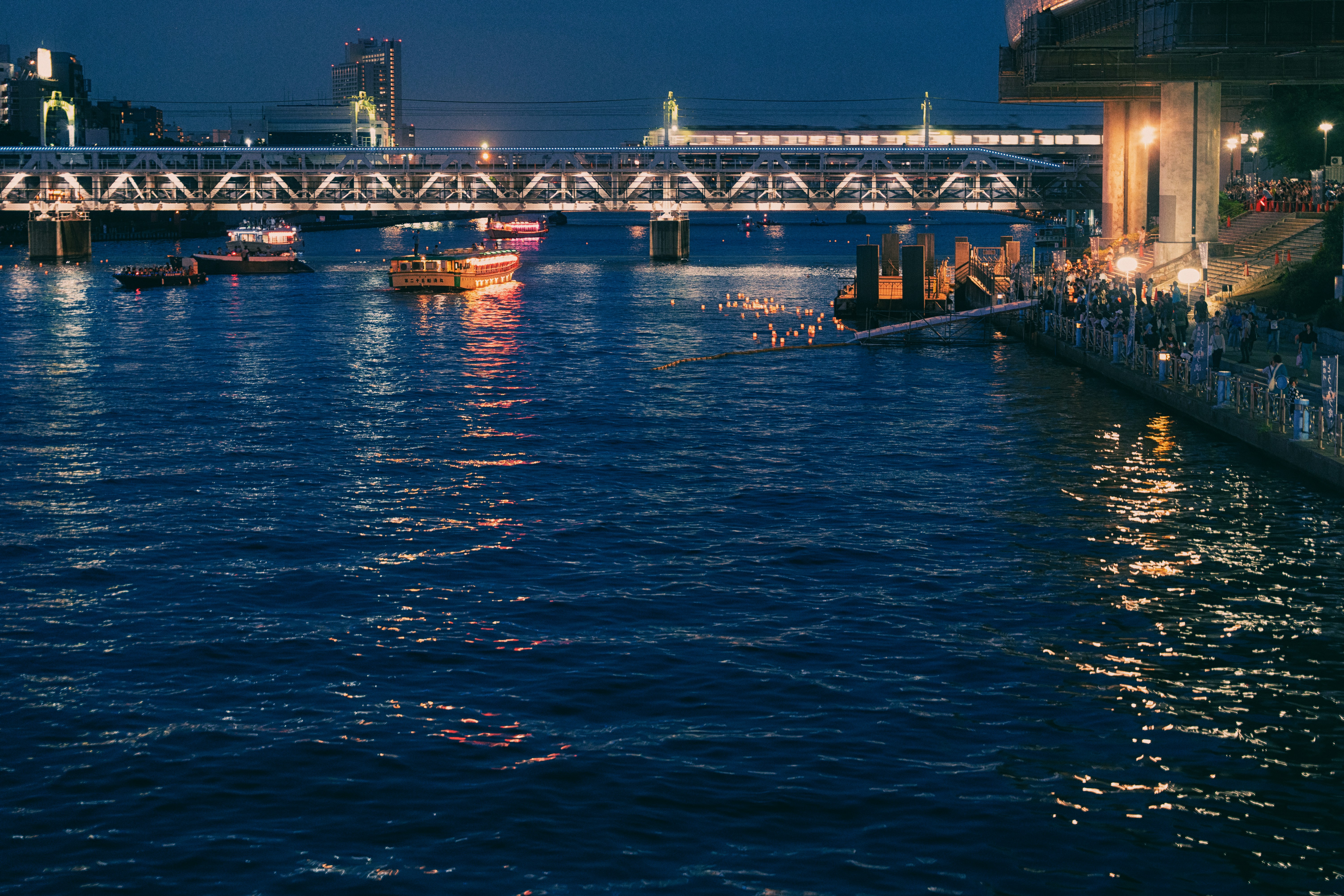 City skyline at night with river and bridge