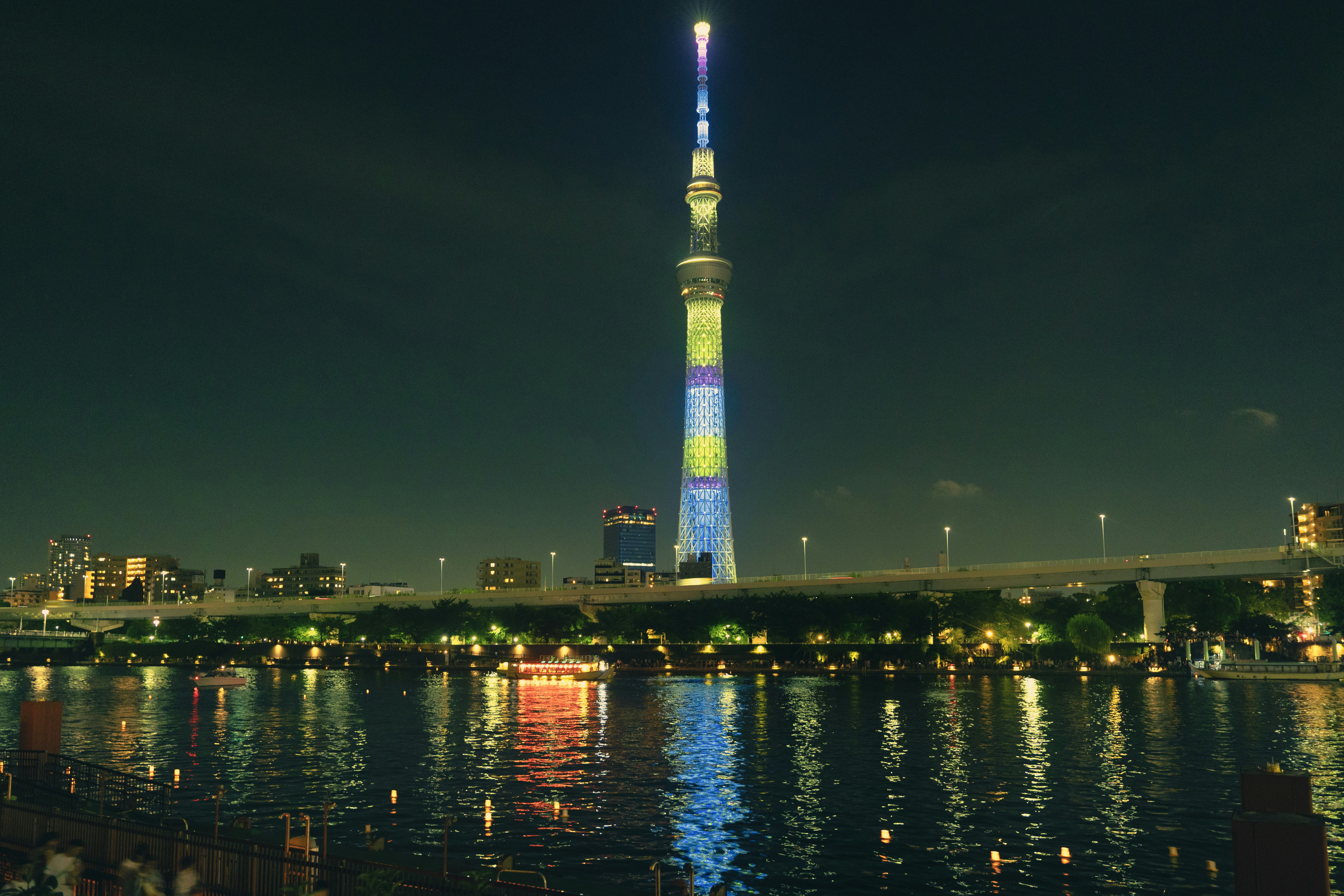 Tall illuminated tower over a city at night