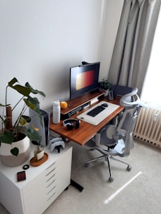A modern home office desk setup with a computer and chair.