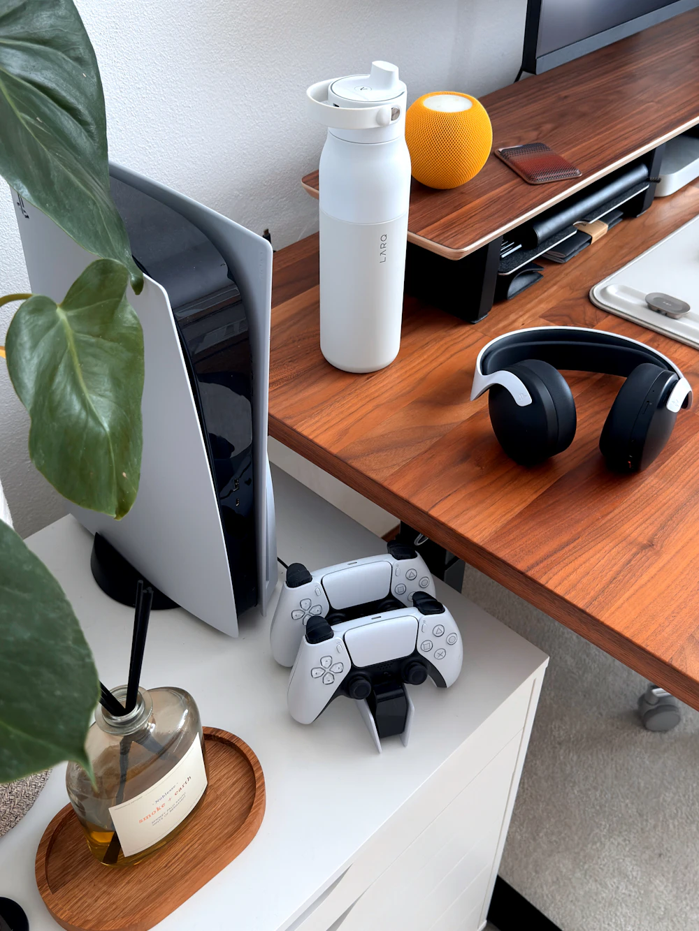 Gaming-Setup mit Konsole, Controllern, Kopfhörern und Wasserflasche als Symbol für ein nikotinfreies Setup