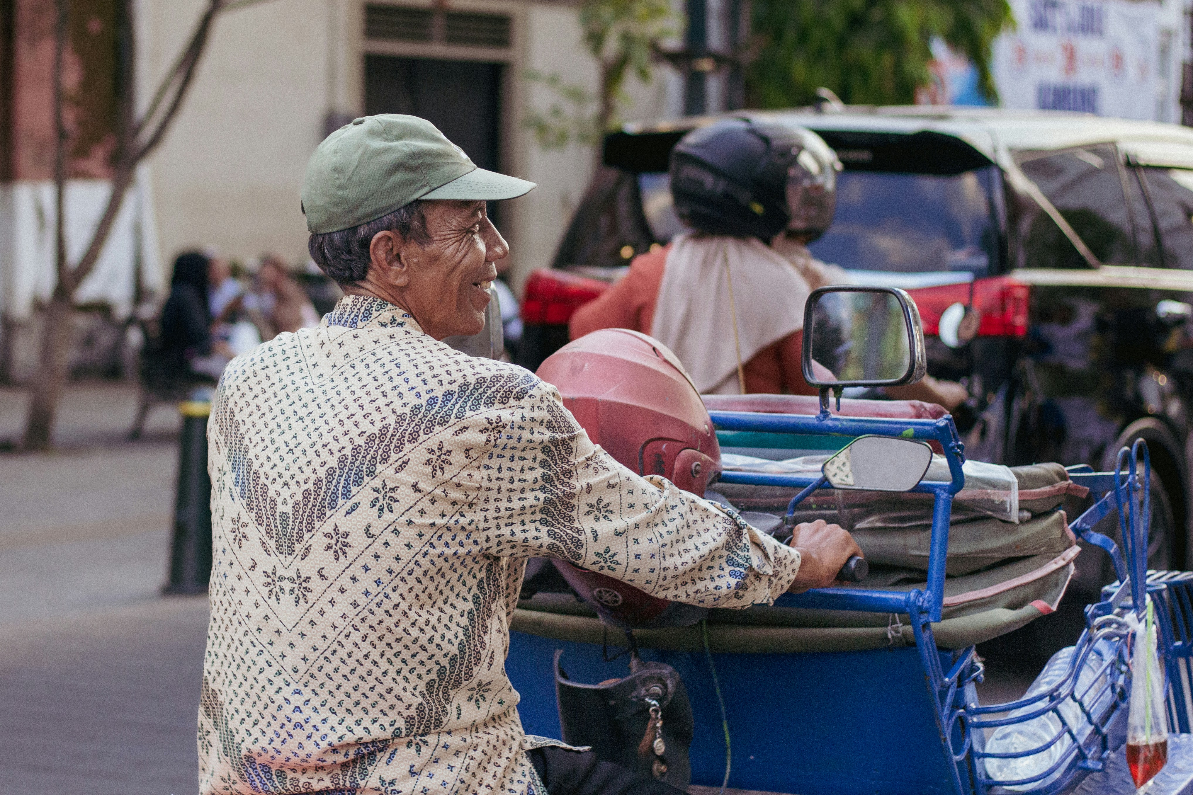 Man driving a three-wheeled vehicle on a street
