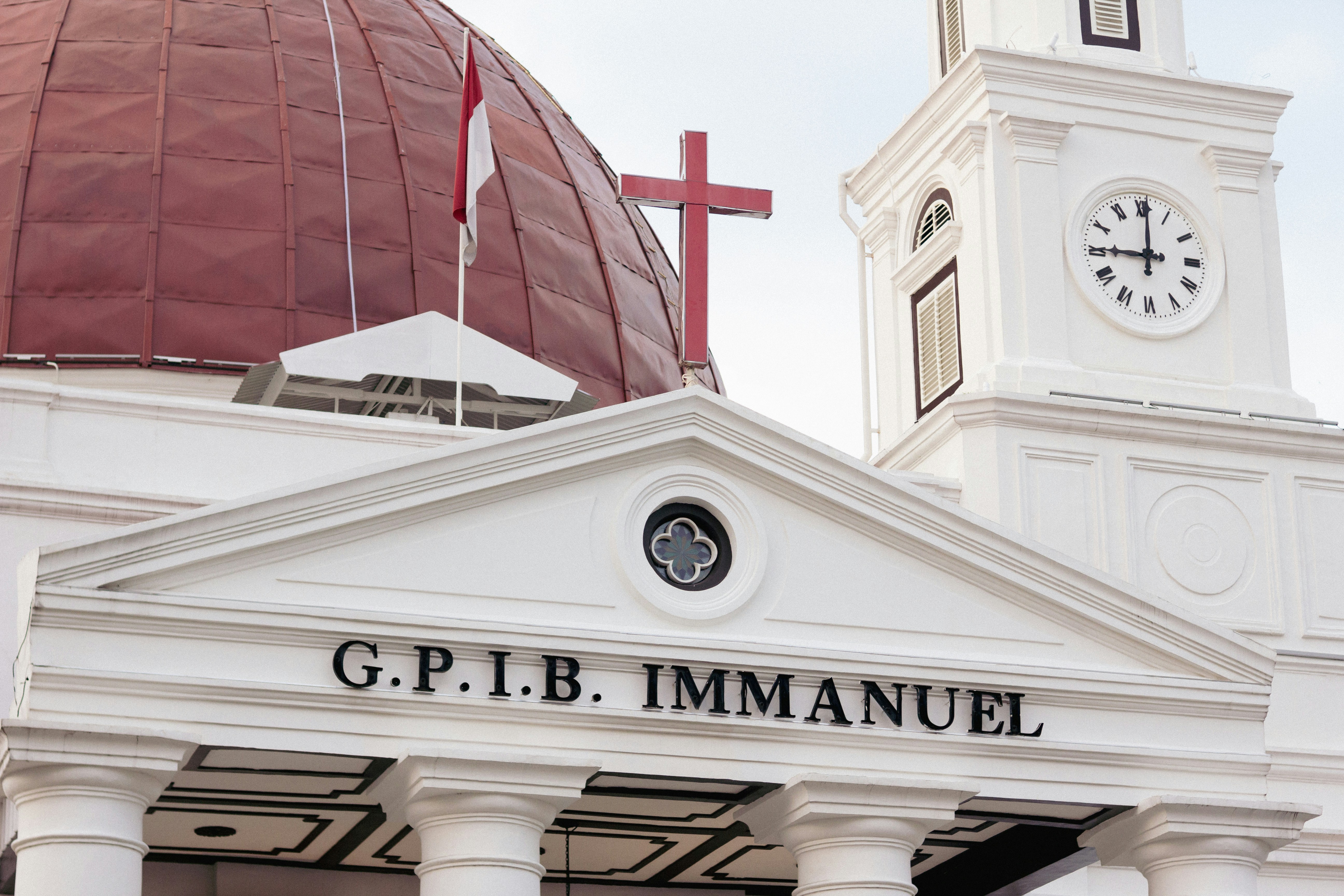 White church building with red dome and cross